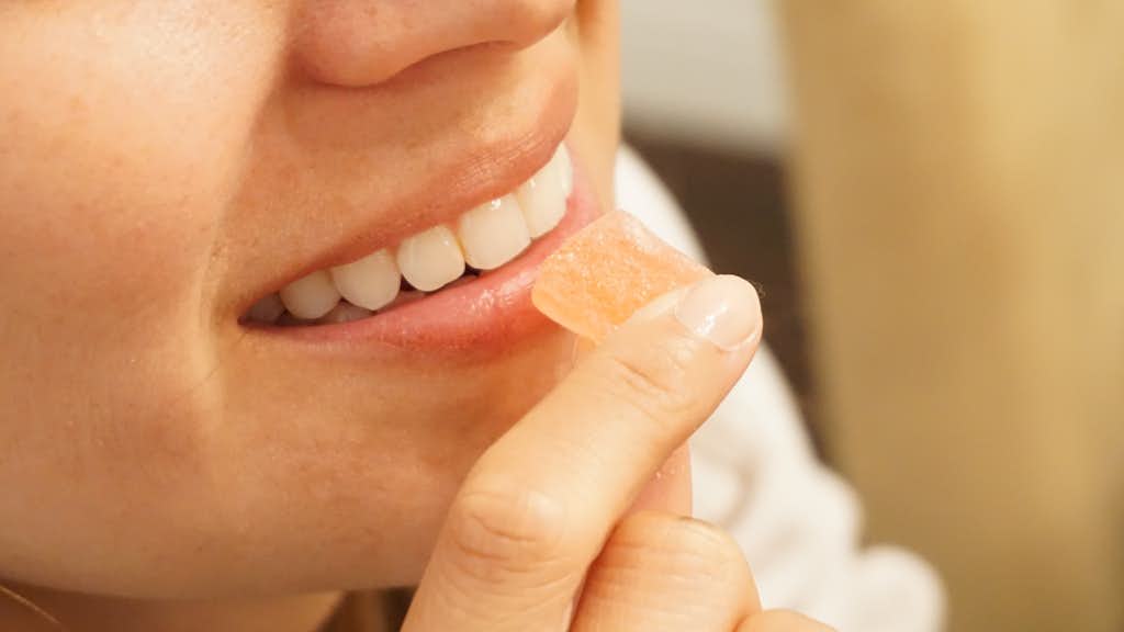 Frau isst ein Cannabis-Edible Gummibärchen