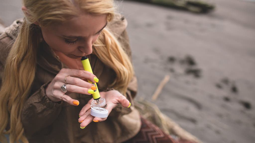 Frau am Strand raucht Cannabis-Konzentrate