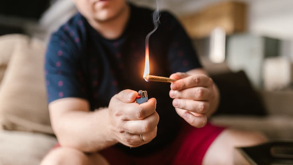 Ein Mann der einen Joint anzündet