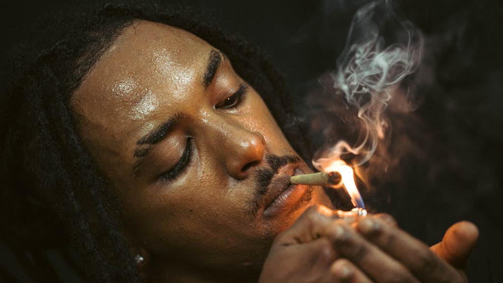 Ein Mann zündet einen Joint an.