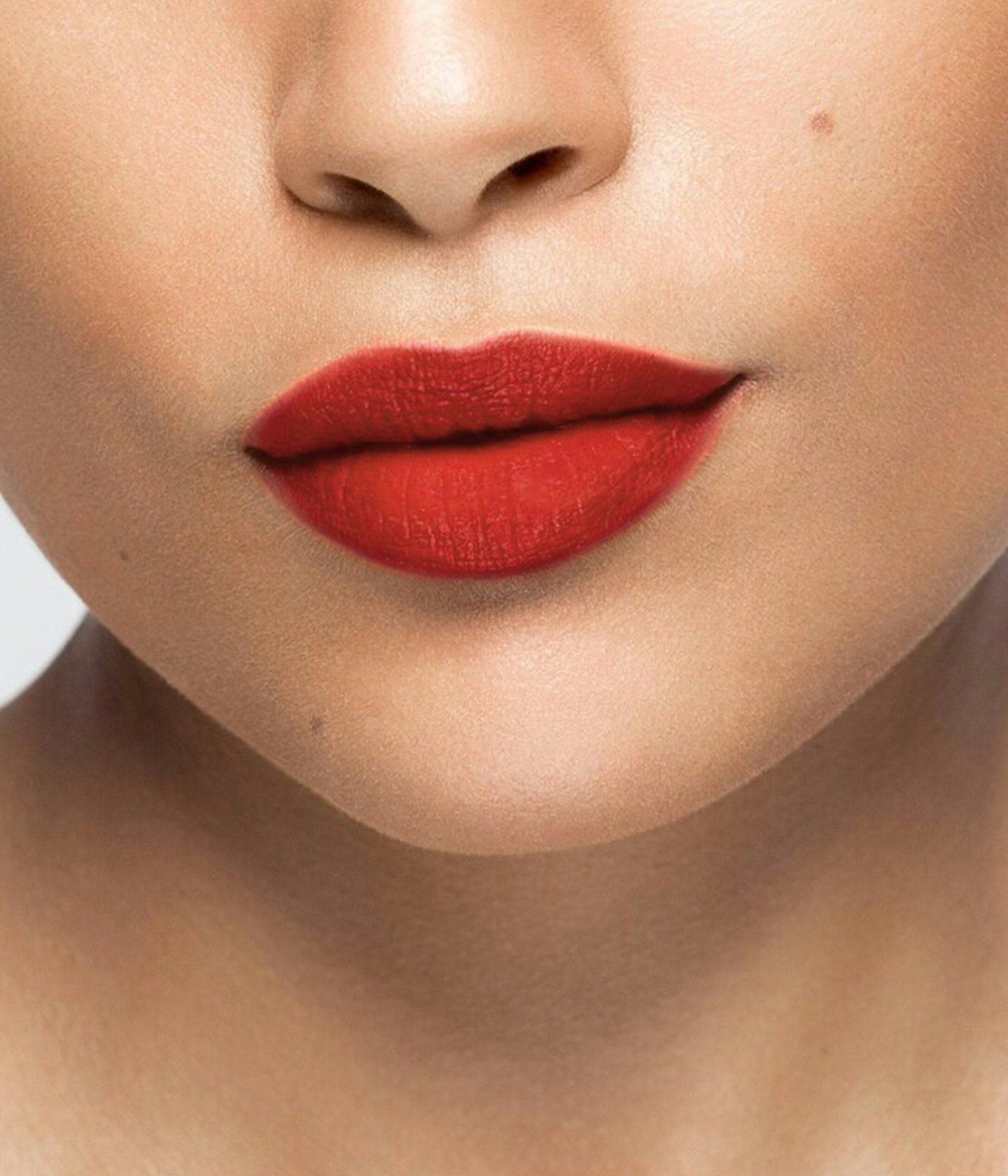 La bouche rouge rouge à lèvres The Red Andreea sur les lèvres d’un mannequin à la peau au teint moyen 