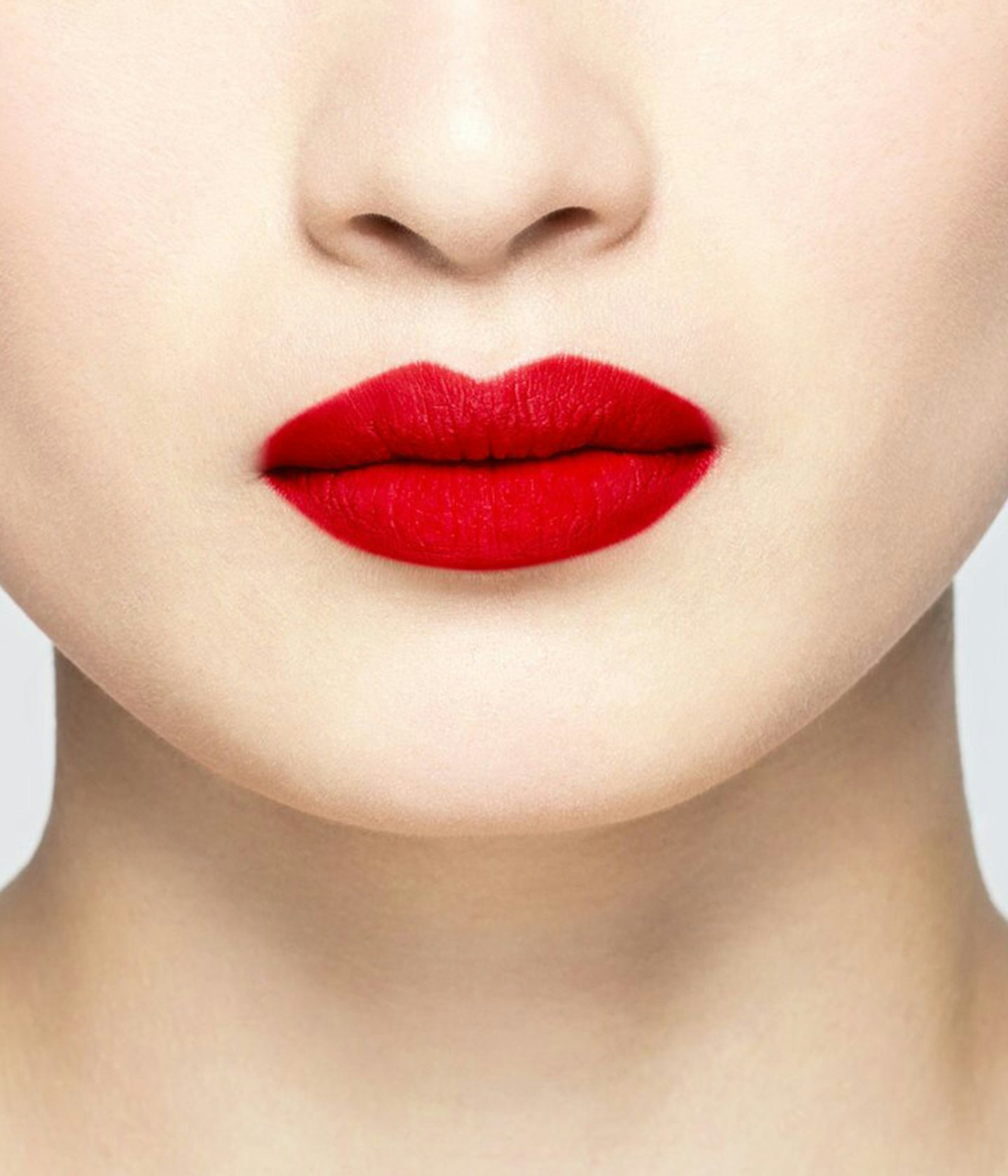 La bouche rouge Regal Red lipstick shade on the lips of an Asian model