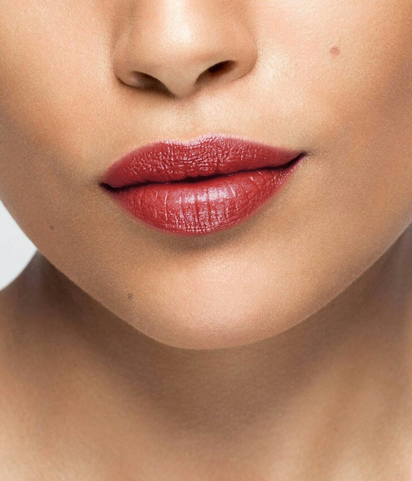 La bouche rouge rouge à lèvres SW1X sur les lèvres d’un mannequin à la peau au teint moyen 