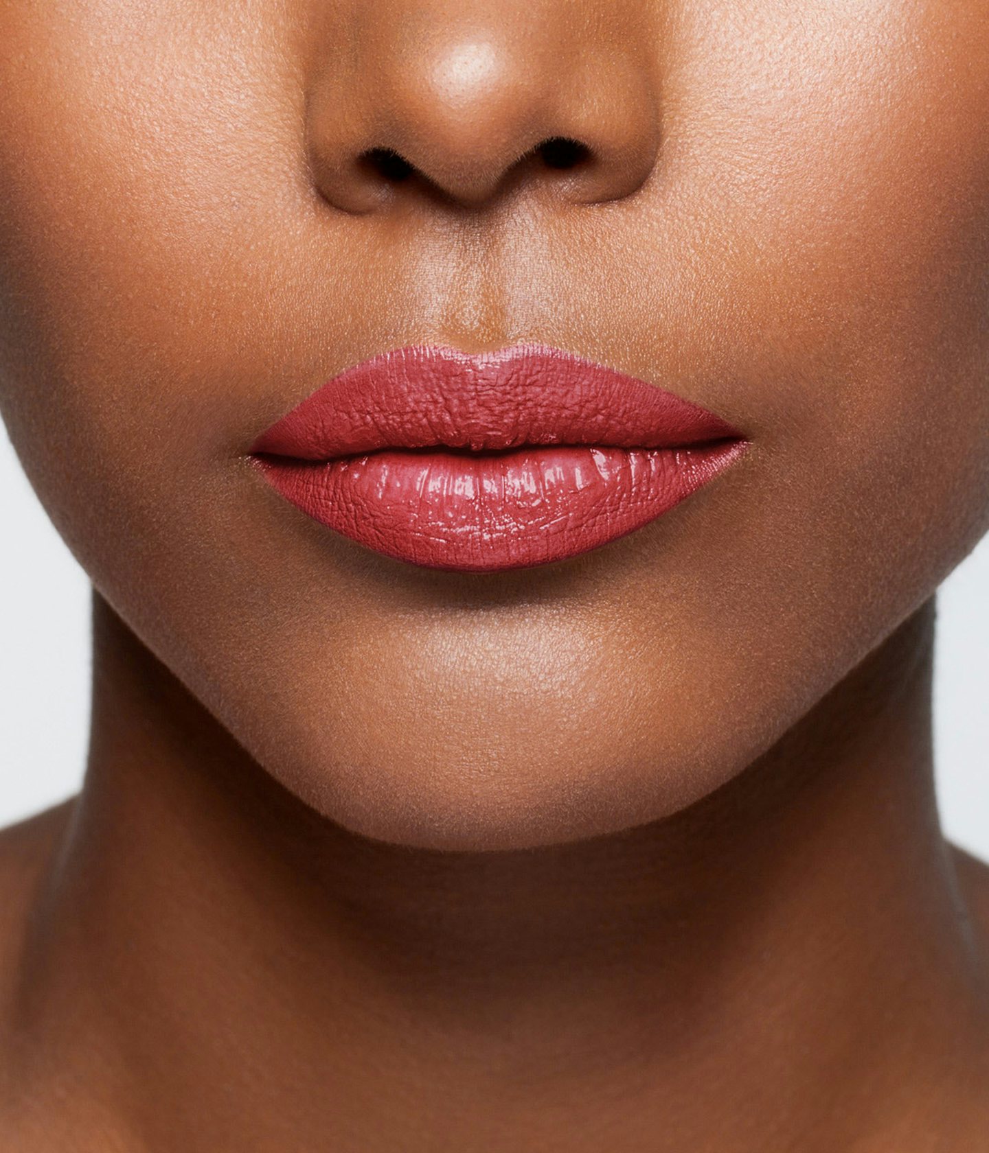 La bouche rouge rouge à lèvres Brompton sur les lèvres d’un mannequin à la peau foncée 