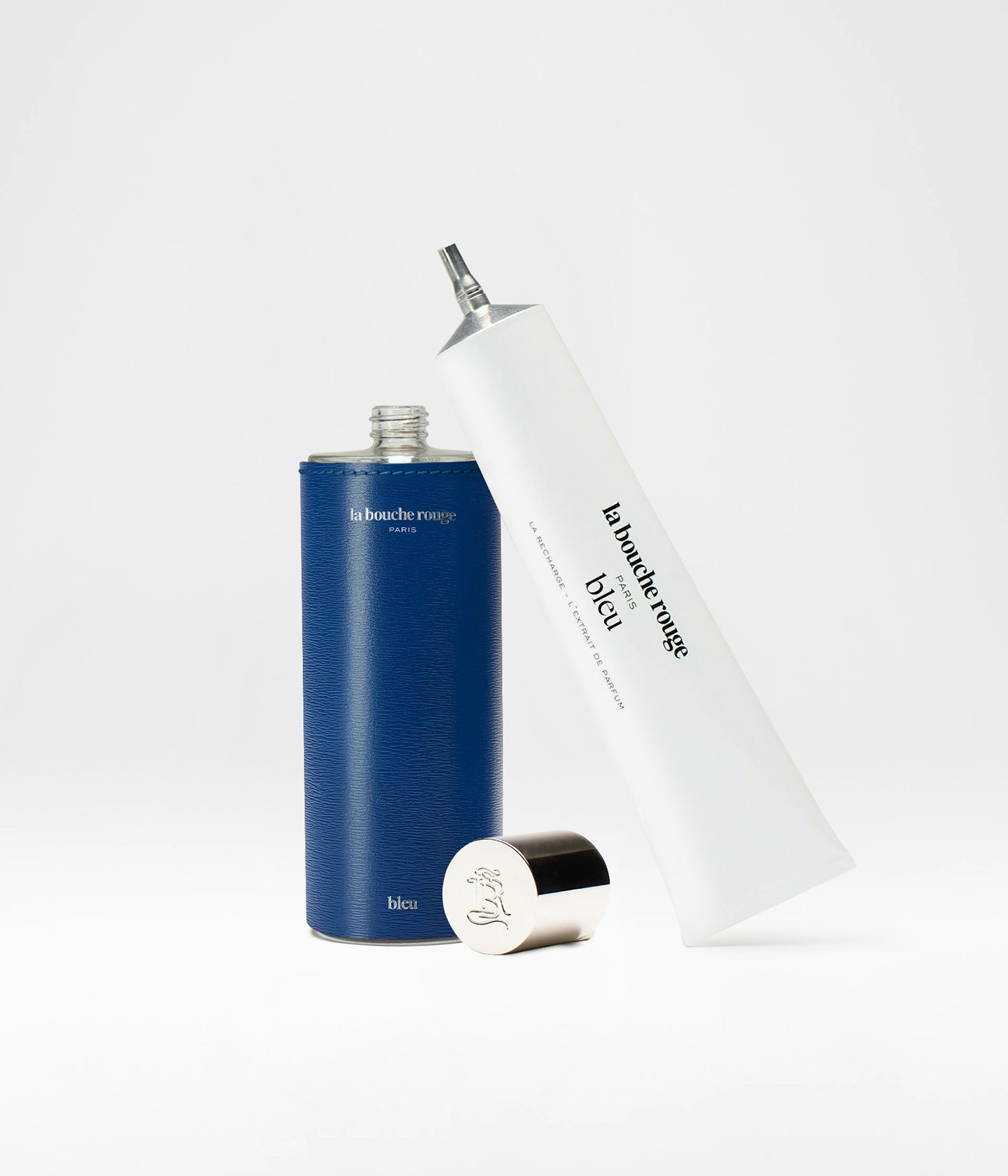 La bouche rouge Extrait de Parfum Bleu dans un écrin en cuir bleu et la recharge en aluminium