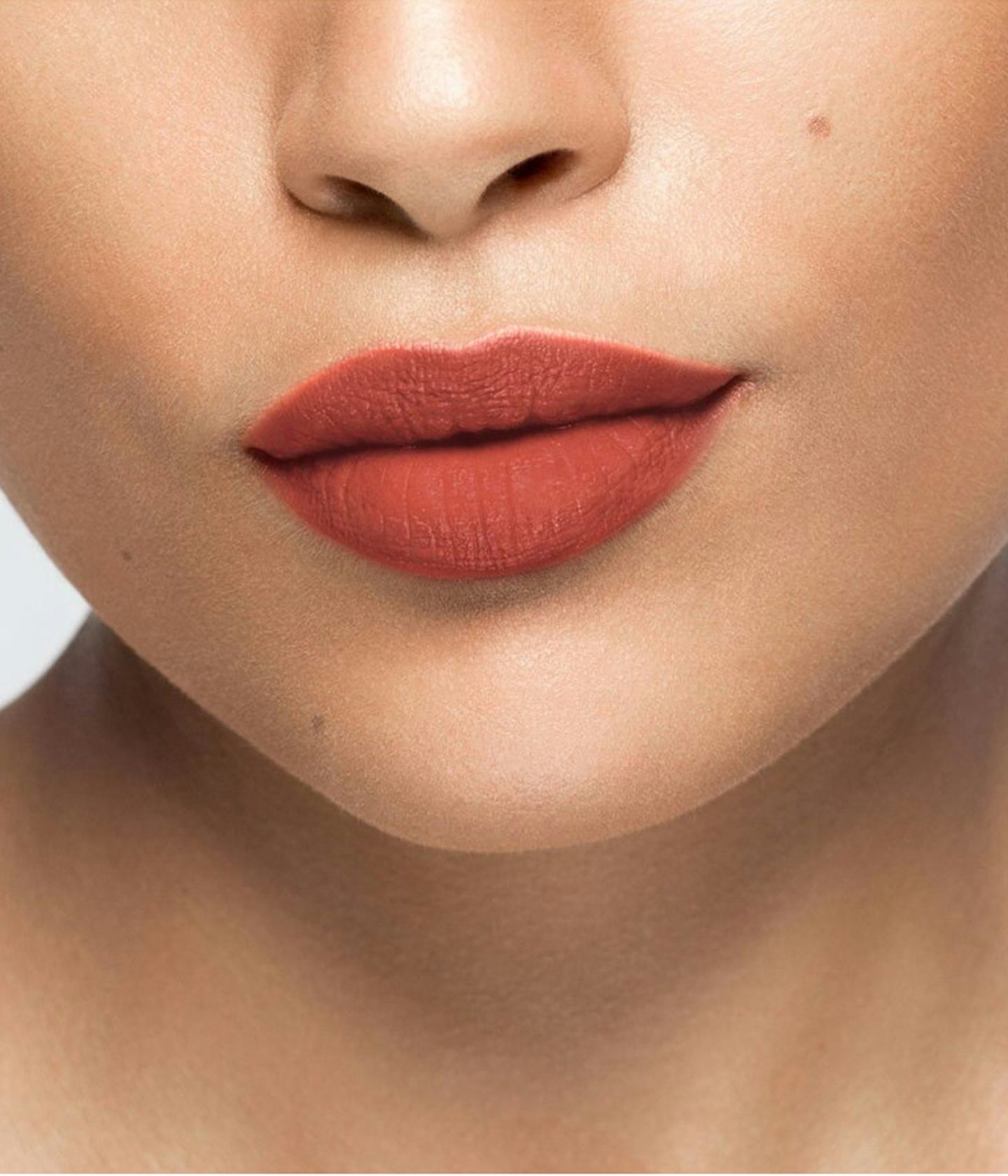 La bouche rouge rouge à lèvres Chetsnut sur les lèvres d’un mannequin à la peau au teint moyen 