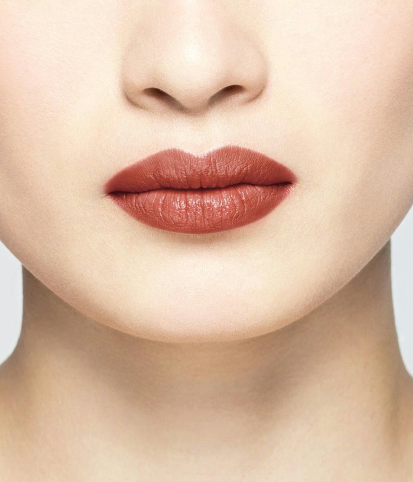 La bouche rouge rouge à lèvres Nude Red sur les lèvres d’un mannequin asiatique 