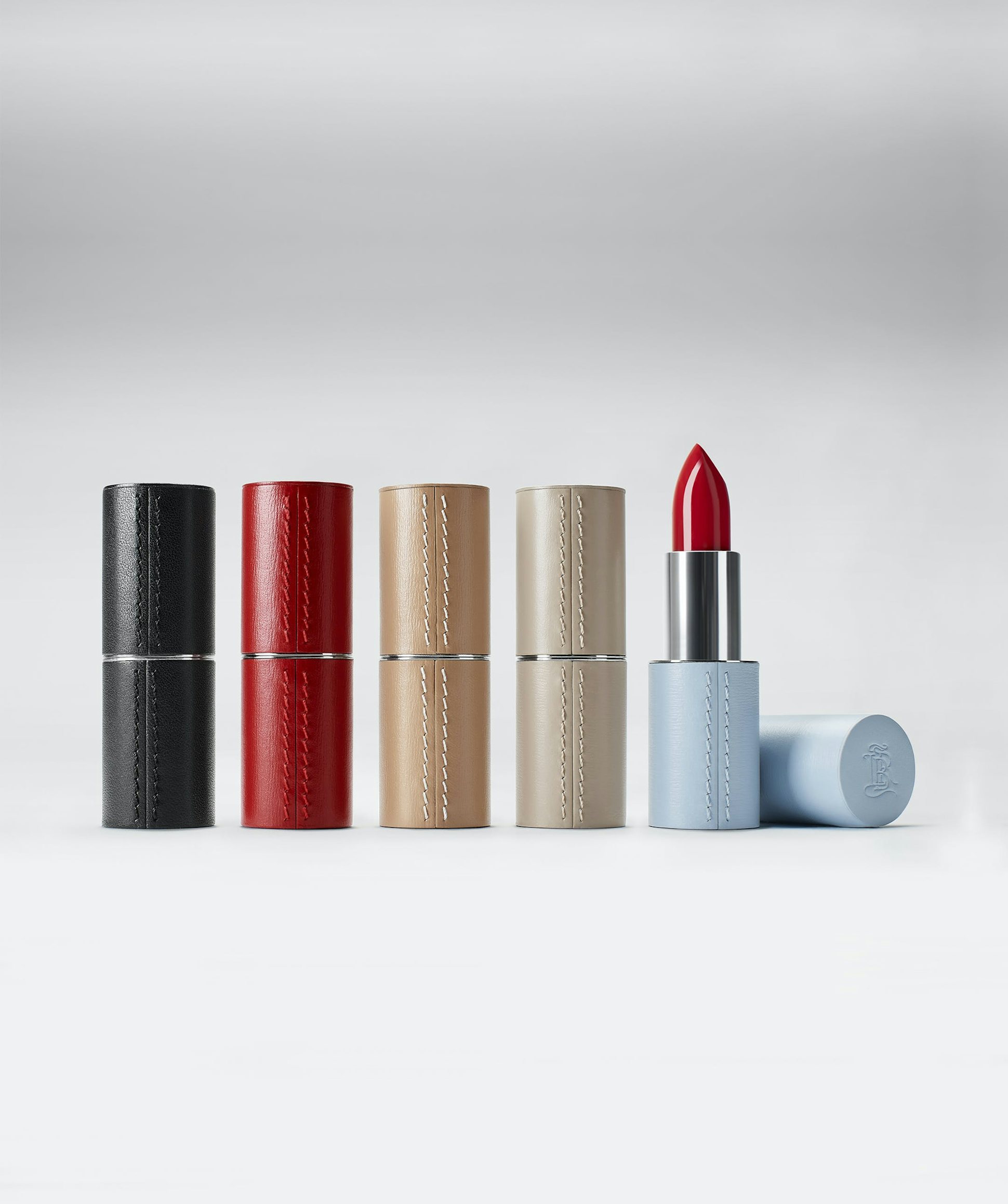 La bouche rouge fine leather lipstick case family with the black, red, camel, beige and blue case with a red lipstick shade