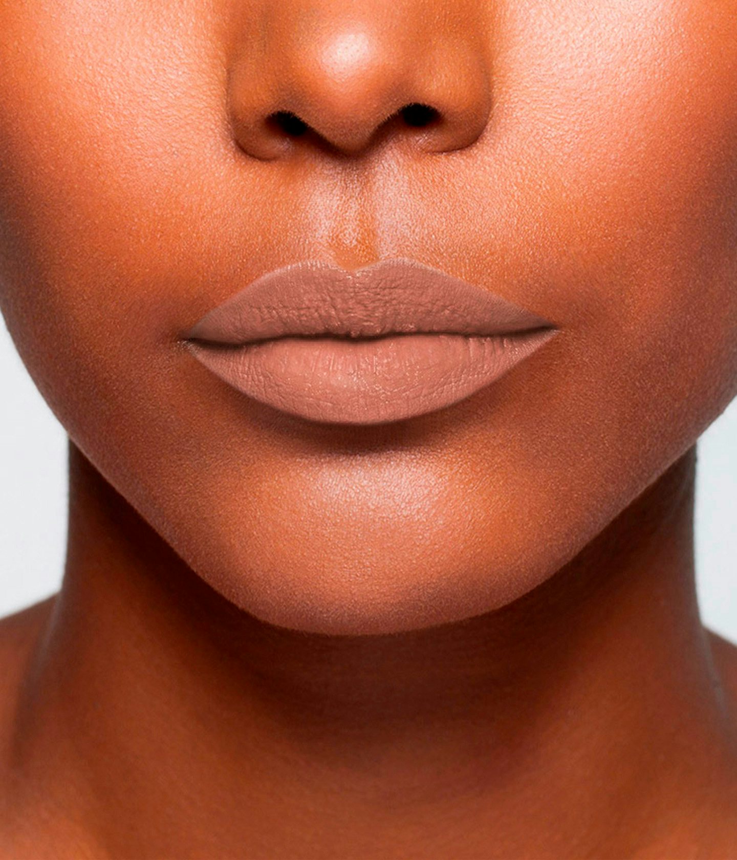 La bouche rouge Nude Brun Matte lipstick shade on the lips of a dark skin model