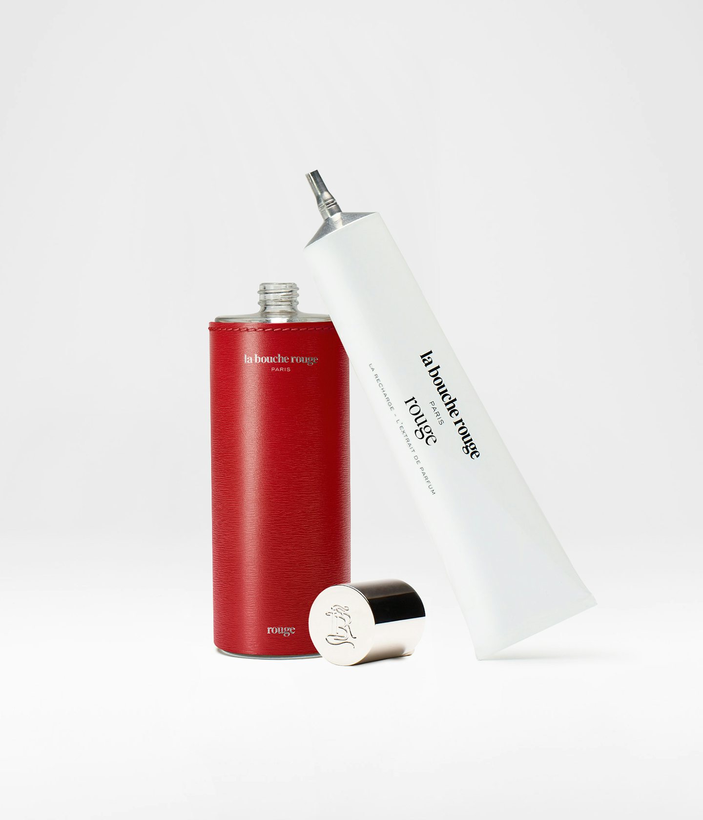 La bouche rouge Extrait de Parfum Rouge dans un écrin en cuir rouge et la recharge en aluminium