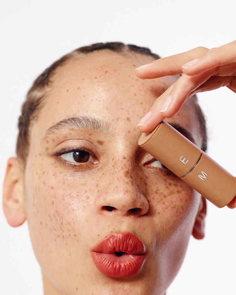 La bouche rouge funny faces campaign model wearing Nude Red lipstick shade with the Camel leather case