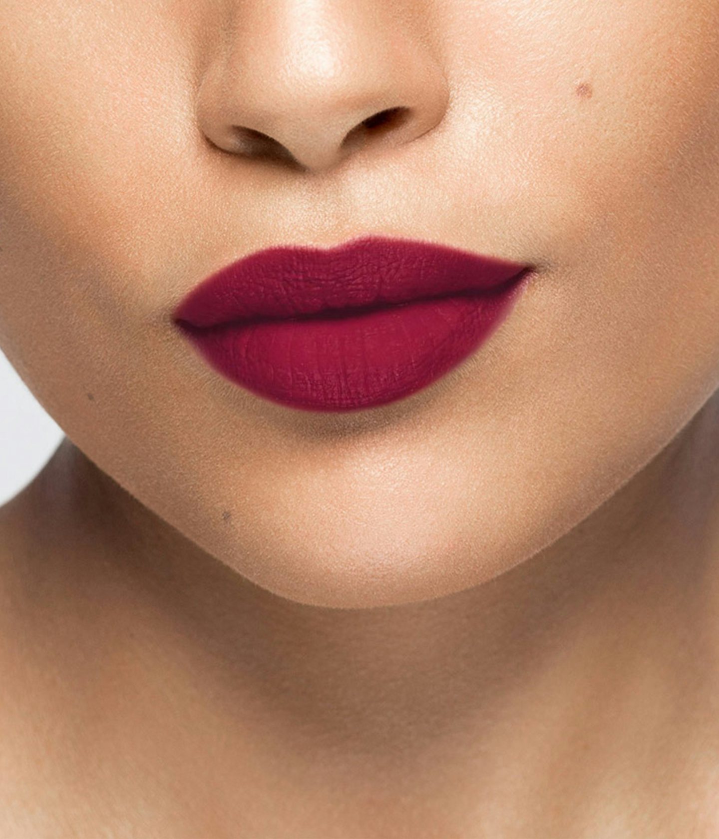 La bouche rouge rouge à lèvres Plum sur les lèvres d’un mannequin à la peau au teint moyen 