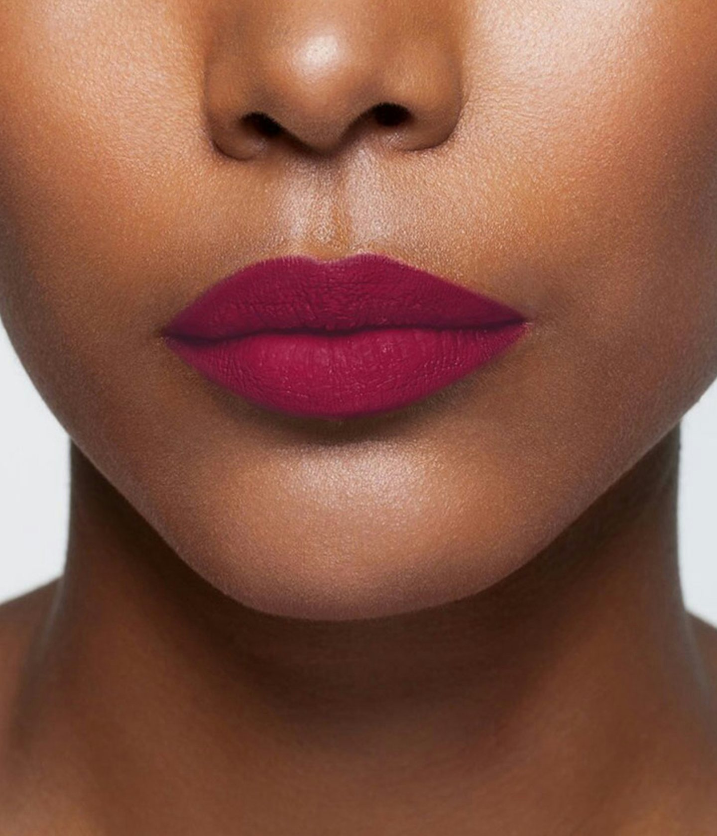 La bouche rouge Plum lipstick shade on the lips of a dark skin model