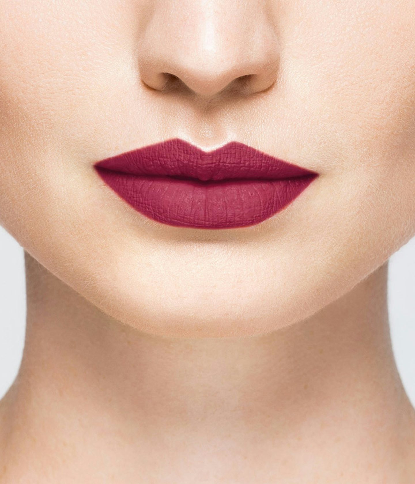 La bouche rouge rouge à lèvres Plum sur les lèvres d’un mannequin à la peau claire 