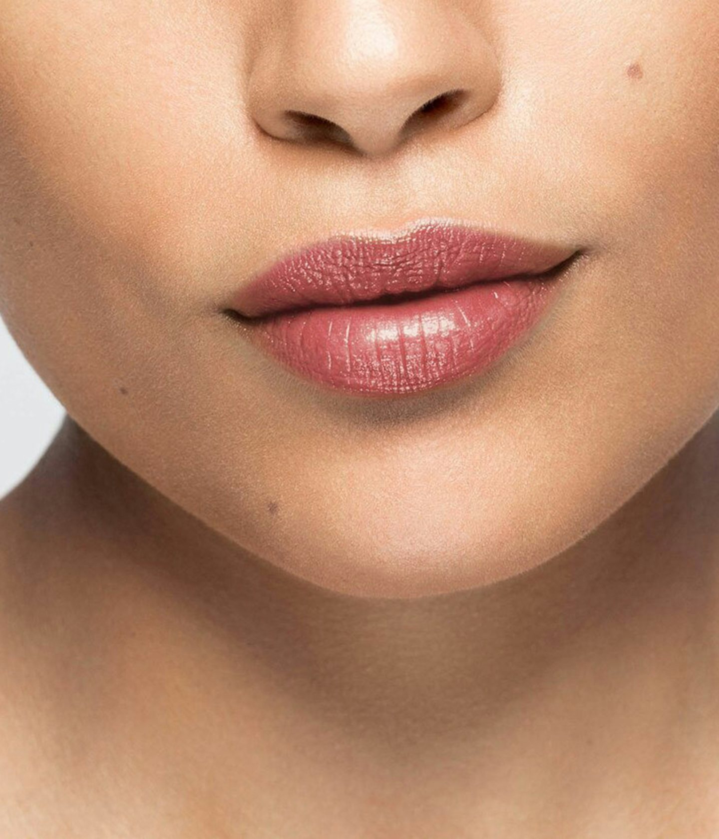 La bouche rouge rouge à lèvres Nude Brown sur les lèvres d’un mannequin à la peau au teint moyen 