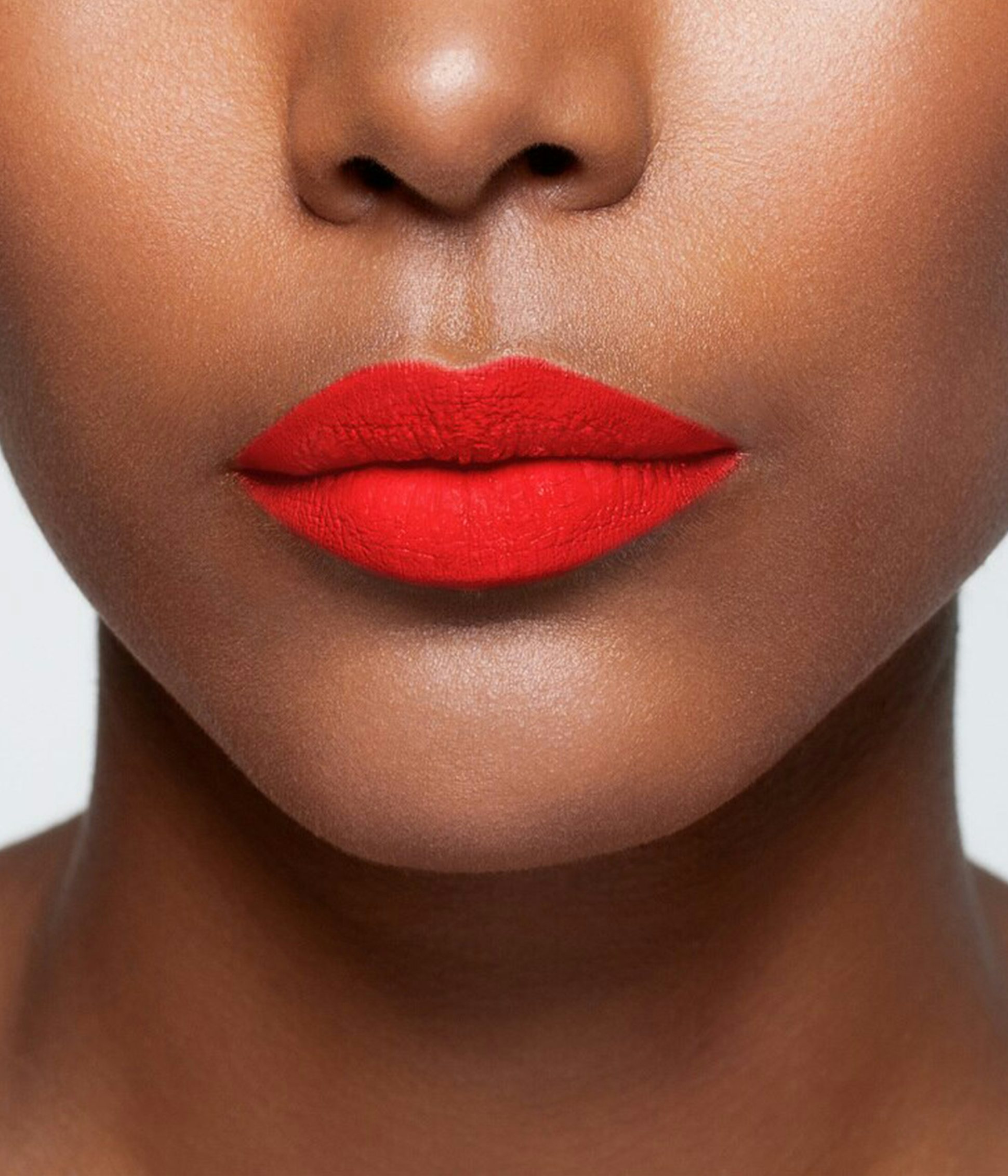 La bouche rouge Neon Giedre lipstick shade on the lips of a dark skin model