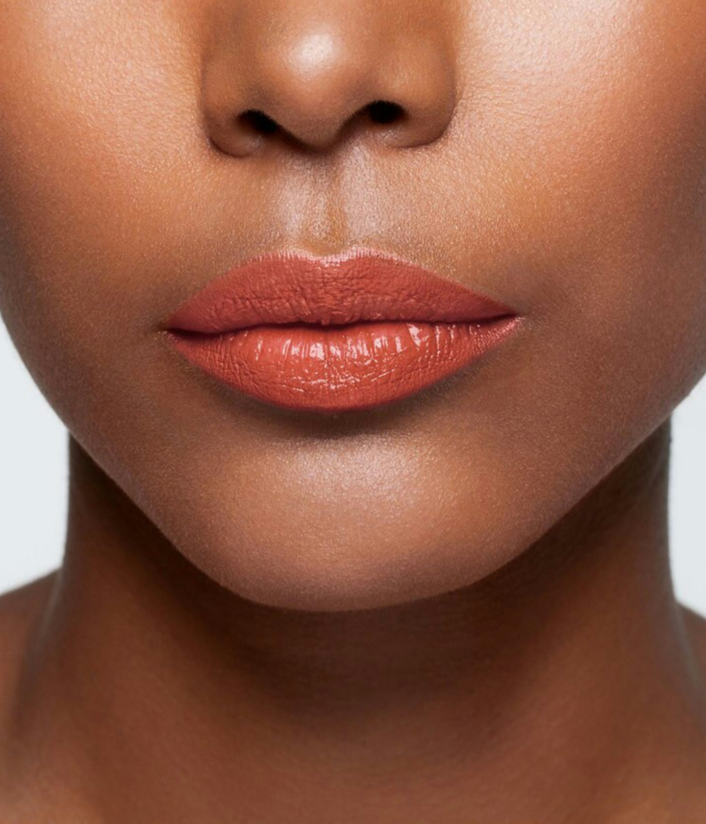 La bouche rouge Nude Red shade on the lips of a dark skin model