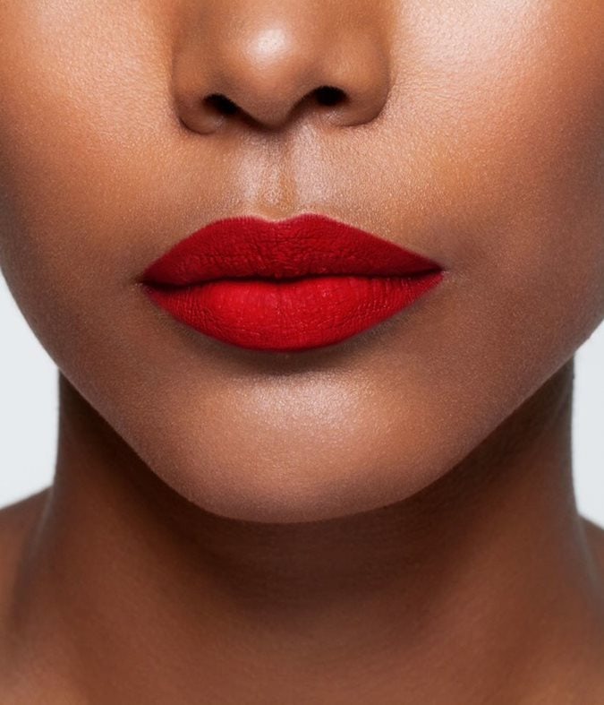 La bouche rouge Pop Art Red lipstick shade on the lips of a dark skin model