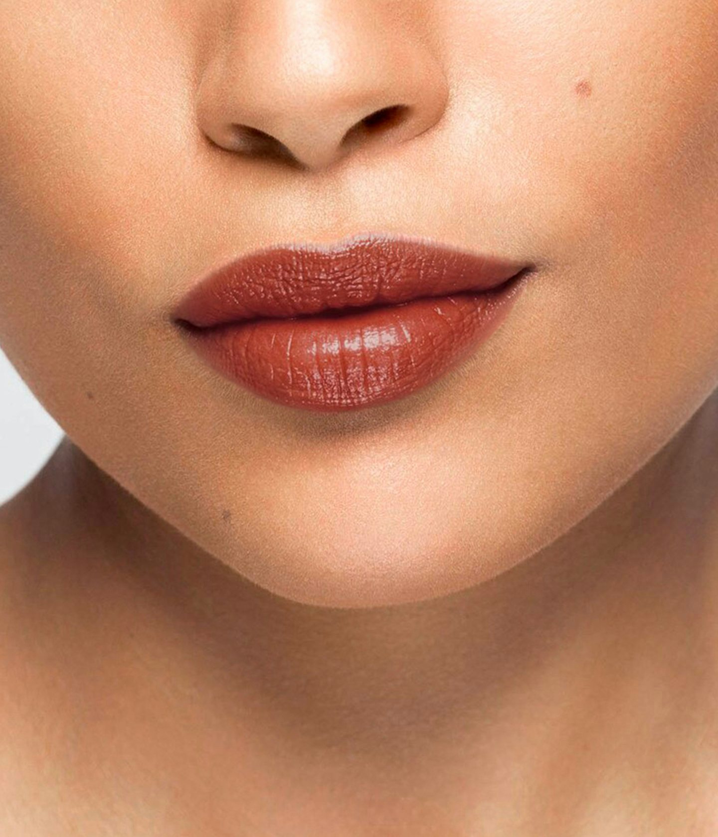 La bouche rouge rouge à lèvres Le baume Koto sur les lèvres d’un mannequin à la peau au teint moyen 