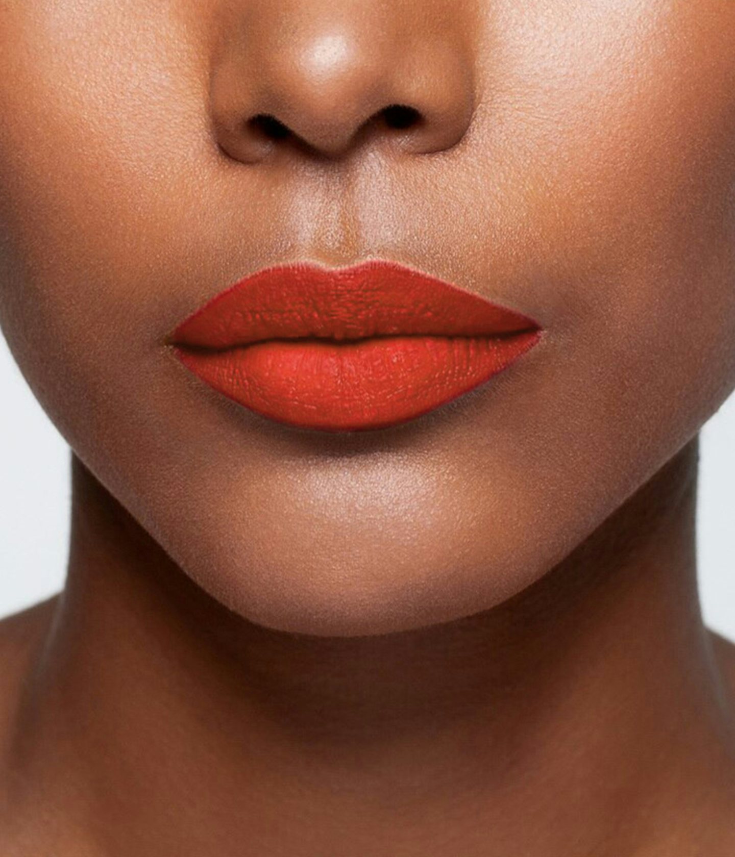 La bouche rouge rouge à lèvres The Red Andreea sur les lèvres d’un mannequin à la peau foncée 