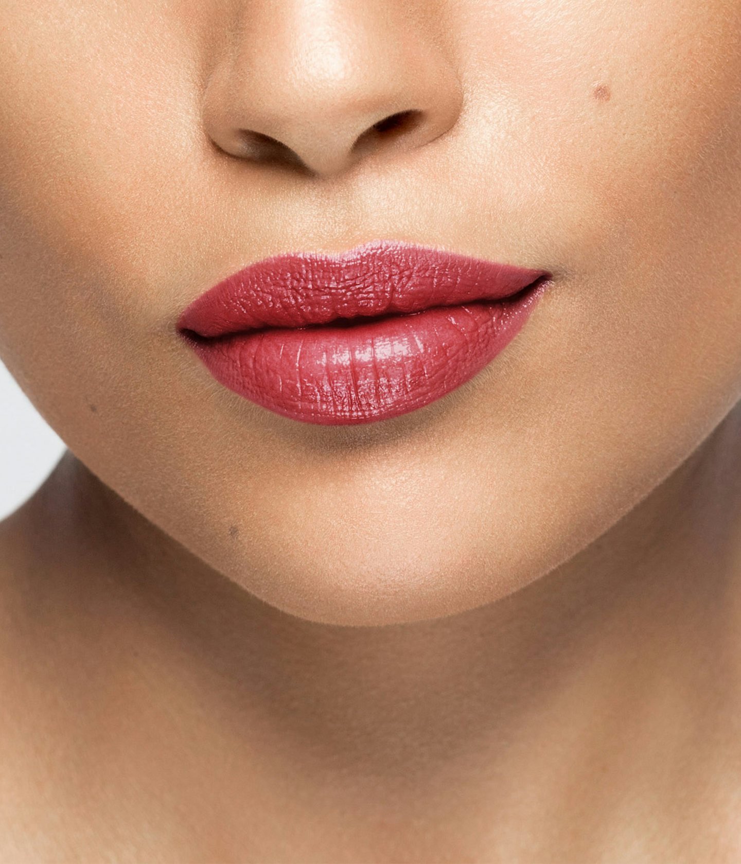 La bouche rouge rouge à lèvres Brompton sur les lèvres d’un mannequin à la peau au teint moyen 