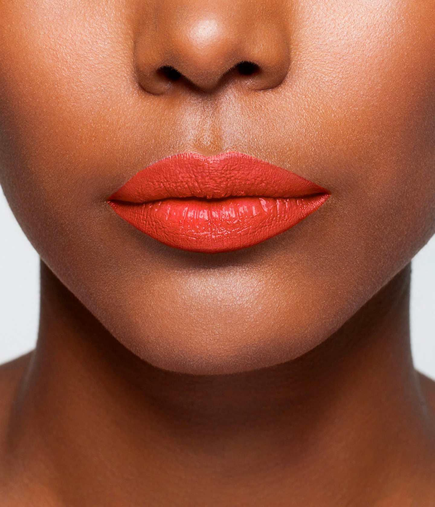 La bouche rouge Le Rouge Elsa lipstick shade on the lips of a dark skin model