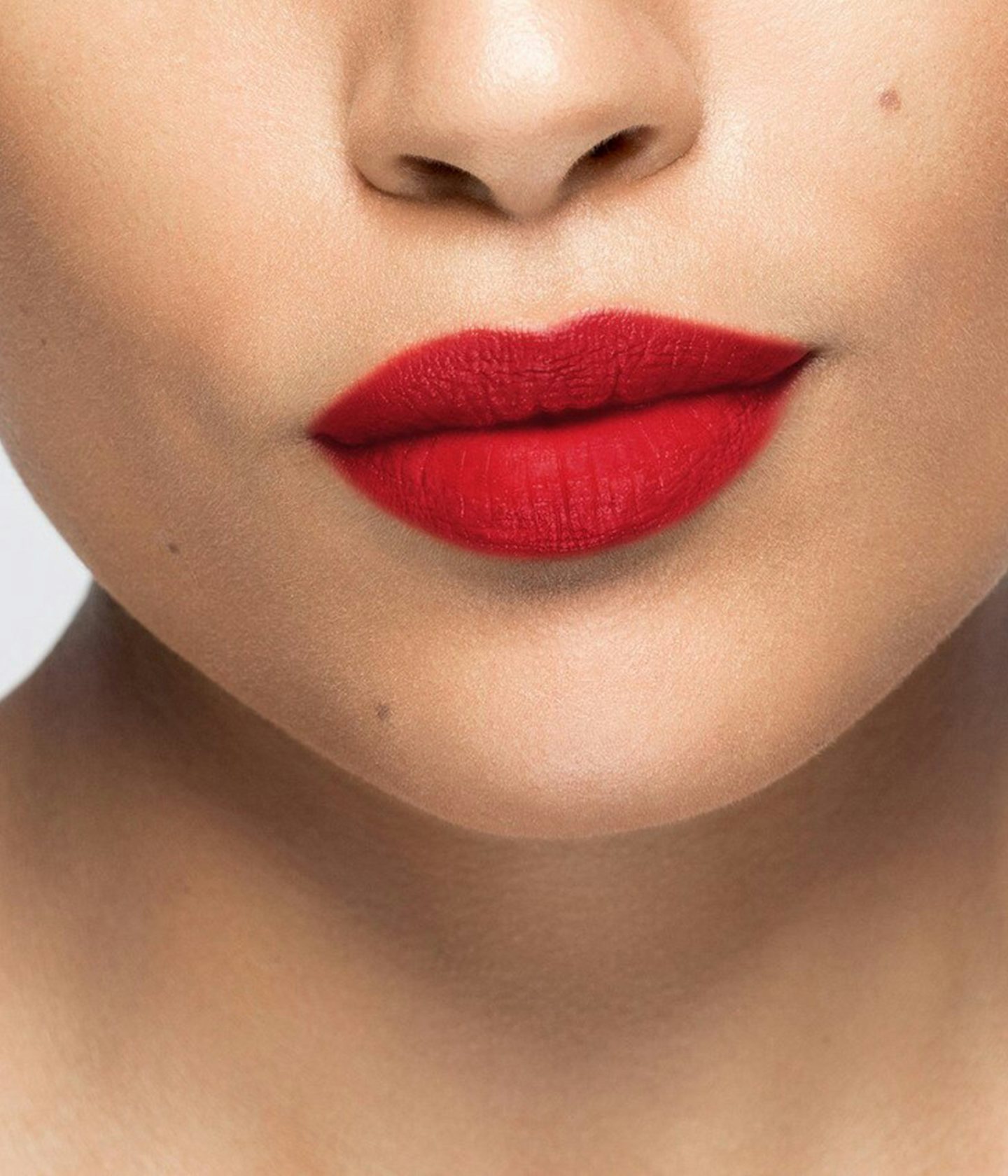 La bouche rouge rouge à lèvres Le Rouge Self Service matte sur les lèvres d’un mannequin à la peau au teint moyen 