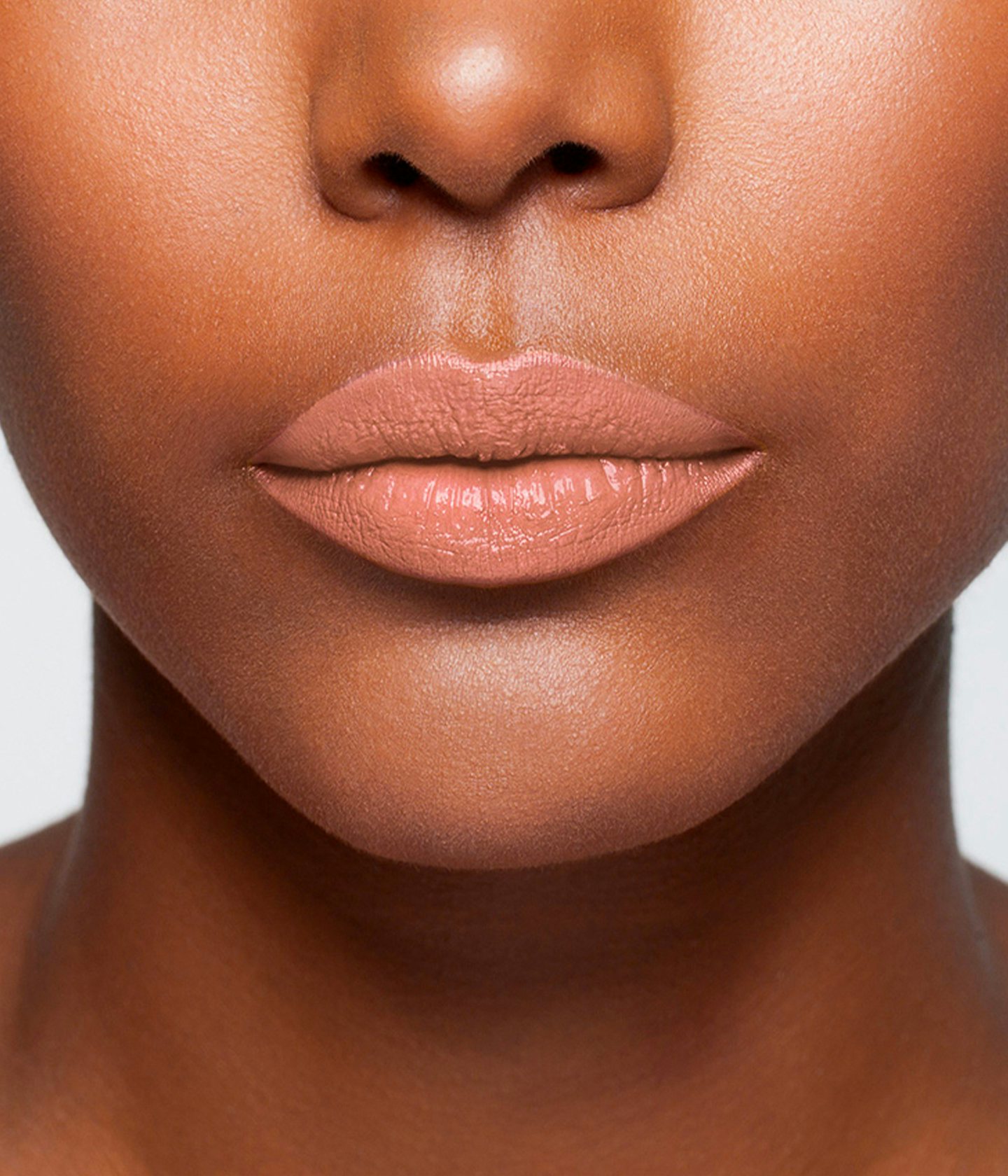 La bouche rouge Le Nude Elsa lipstick shade on the lips of a dark skin model