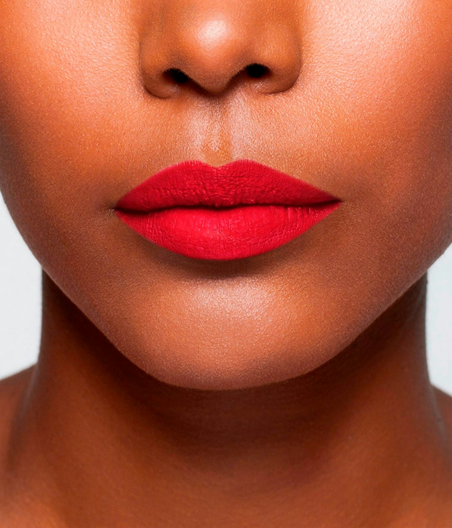 La bouche rouge Le Rouge Montaigne lipstick shade on the lips of a dark skin model