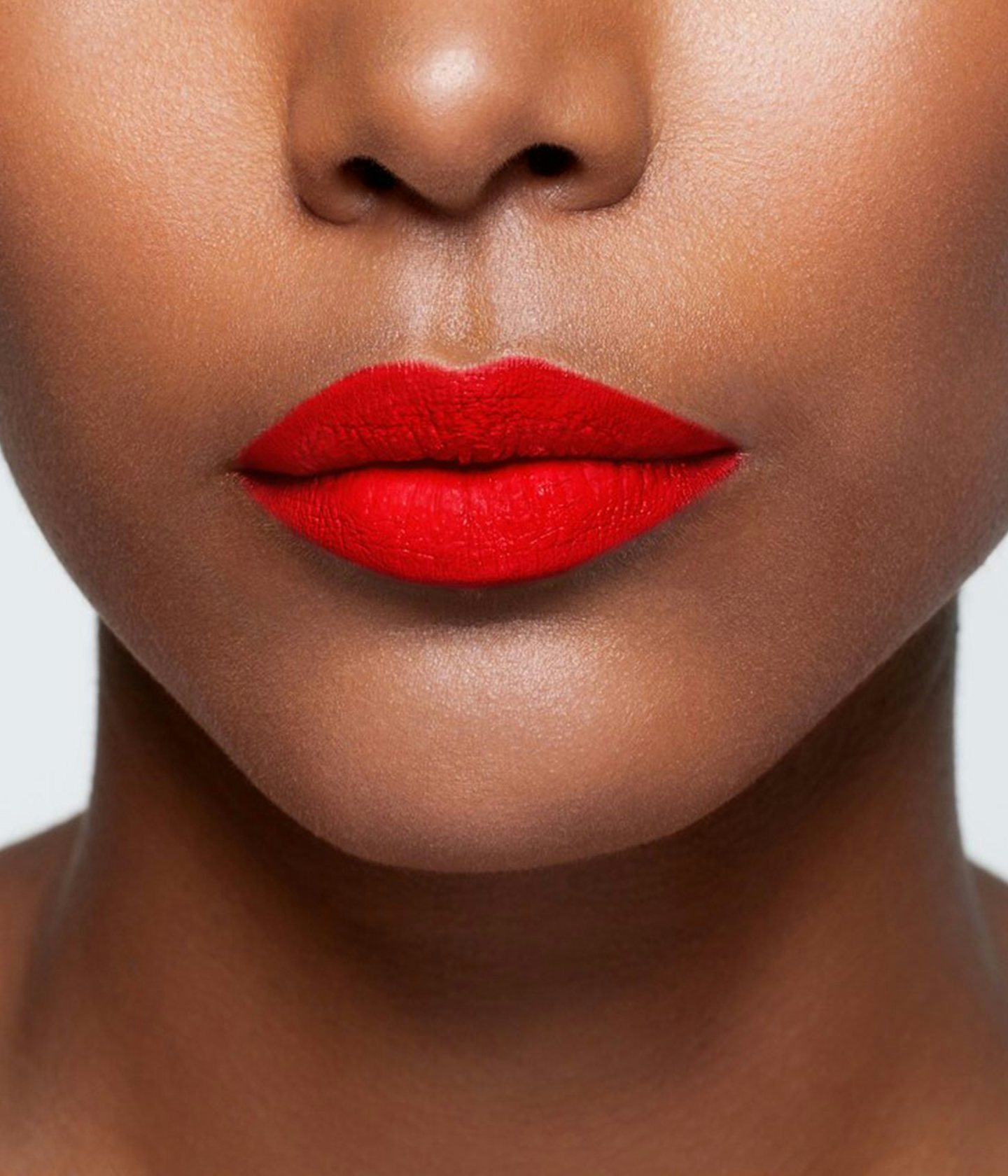 La bouche rouge Regal Red lipstick shade on the lips of a dark skin model