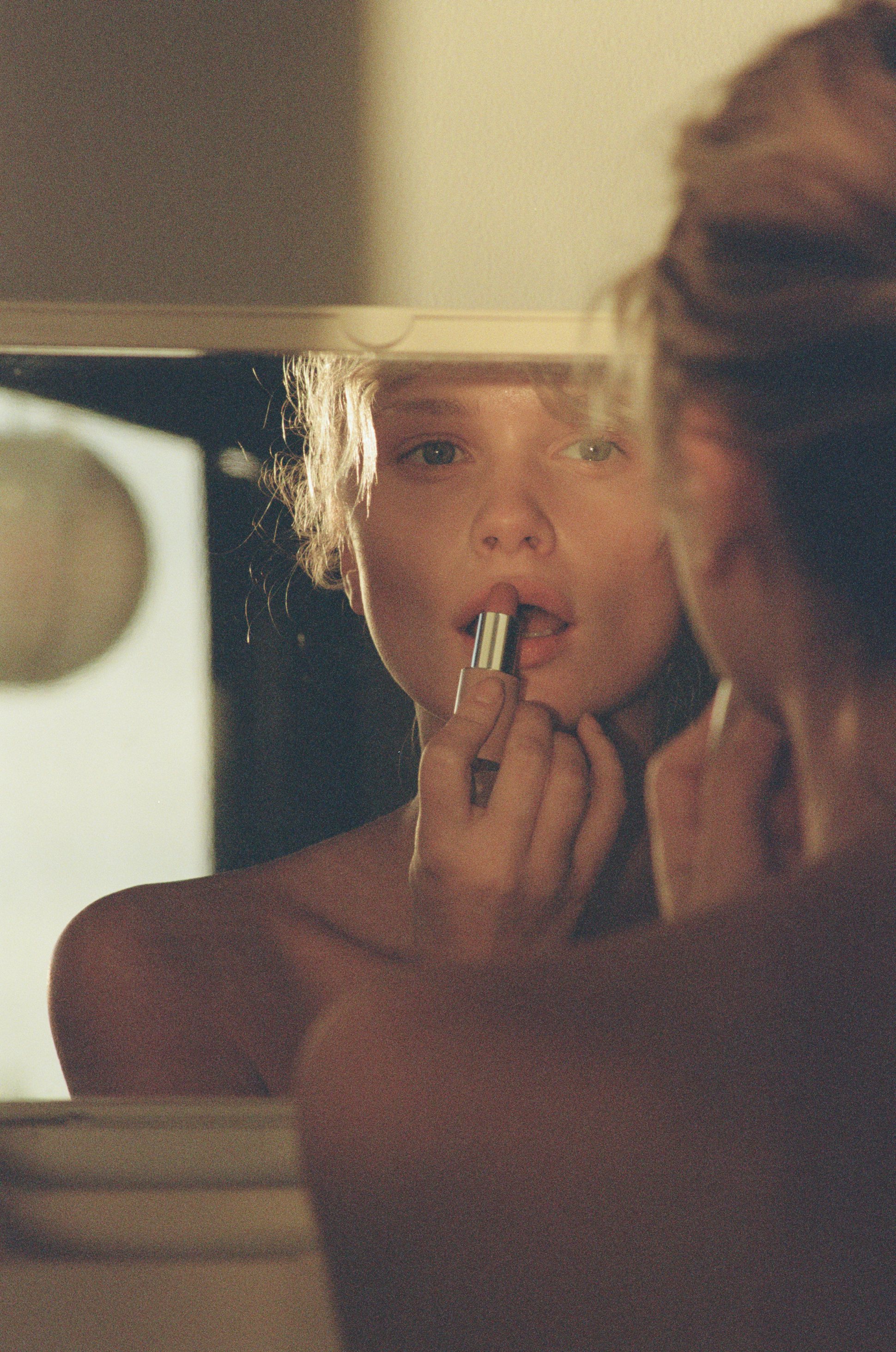 La bouche rouge model wearing nude lipstick in front of the mirror
