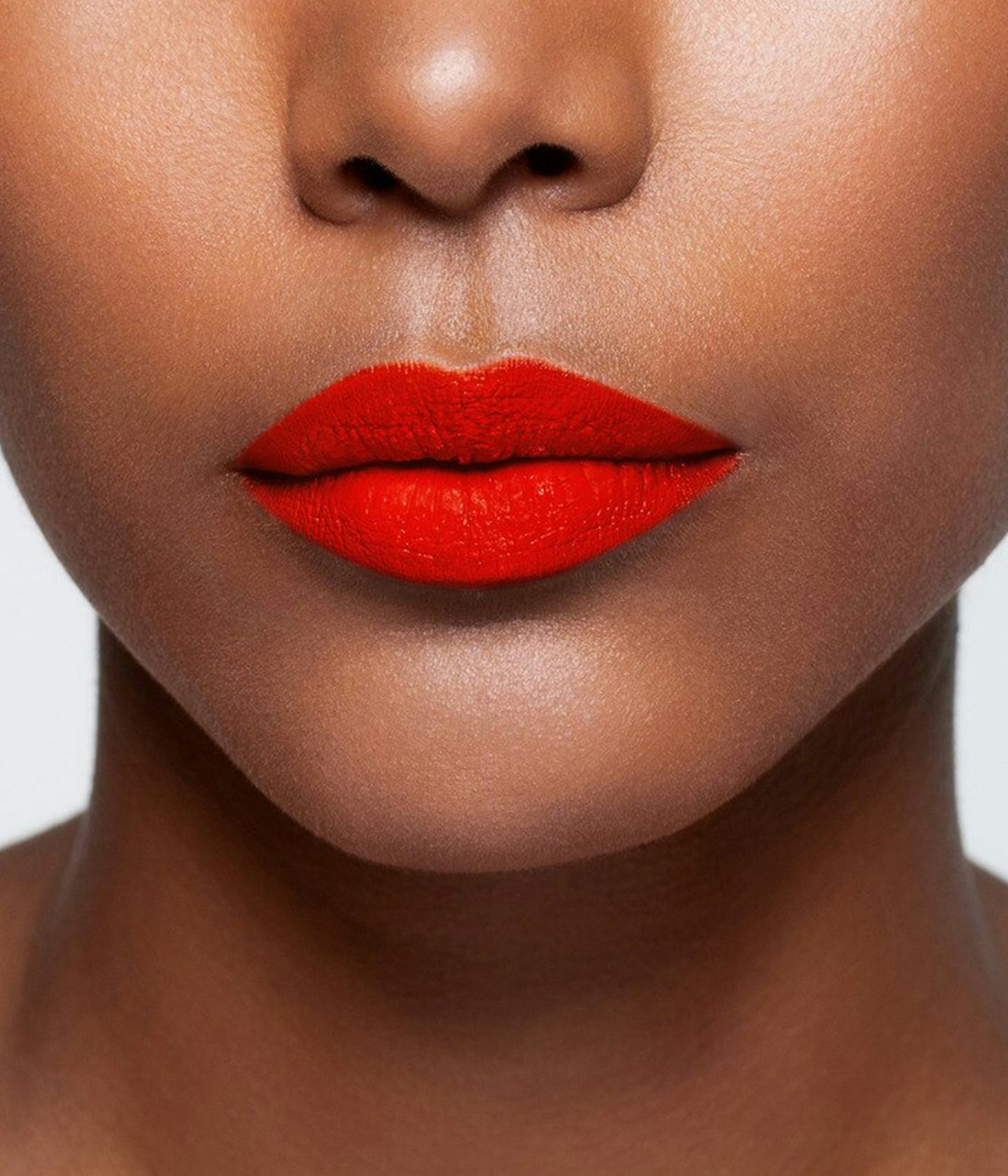La bouche rouge Le Rouge Chloë lipstick shade on the lips of a dark skin model