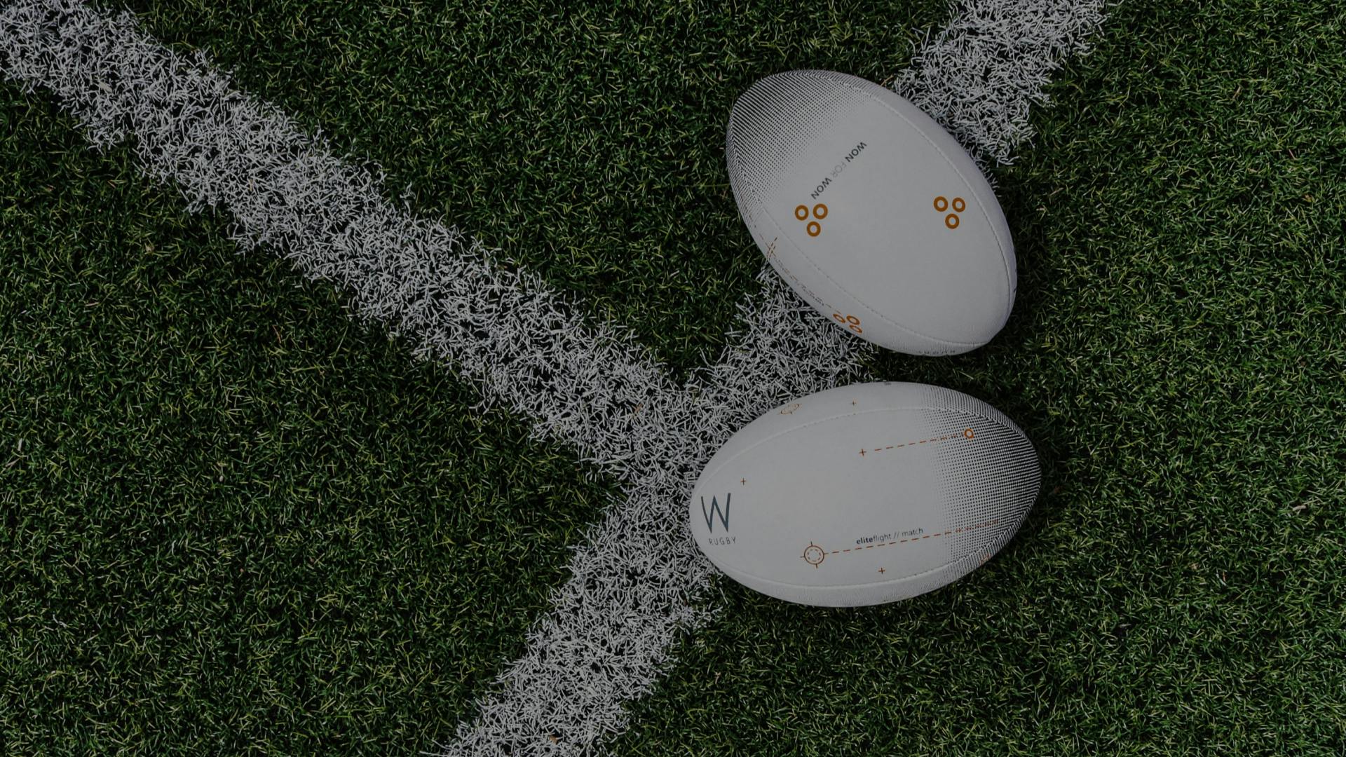2 ballons de rugby sur un terrain avec la marque GMF