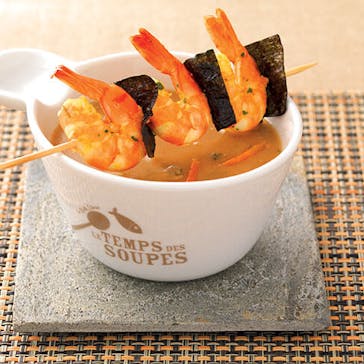 Cream of shellfish soup with prawn skewers
