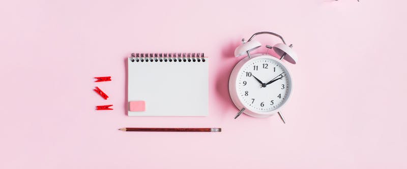 Alarm clock with calendar on pink background - Image for post: The rise of the time tracking app for remote work