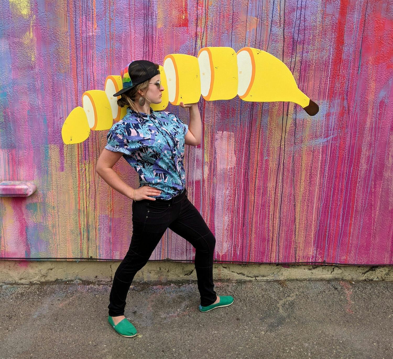A woman holding an illustration of a sliced banana