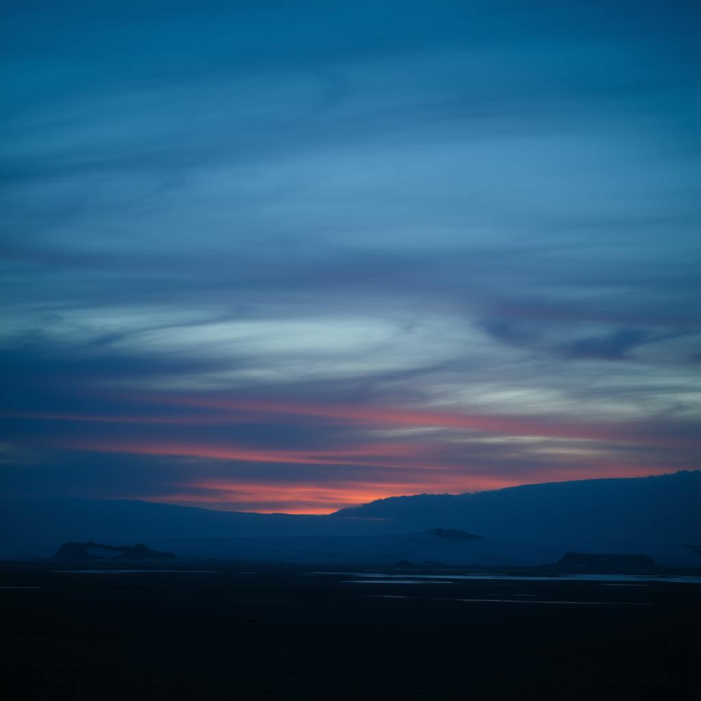 A peaceful twilight scene with flowing blue and pink tones in the sky, capturing the harmony of monochromatic color schemes in the landscape.
