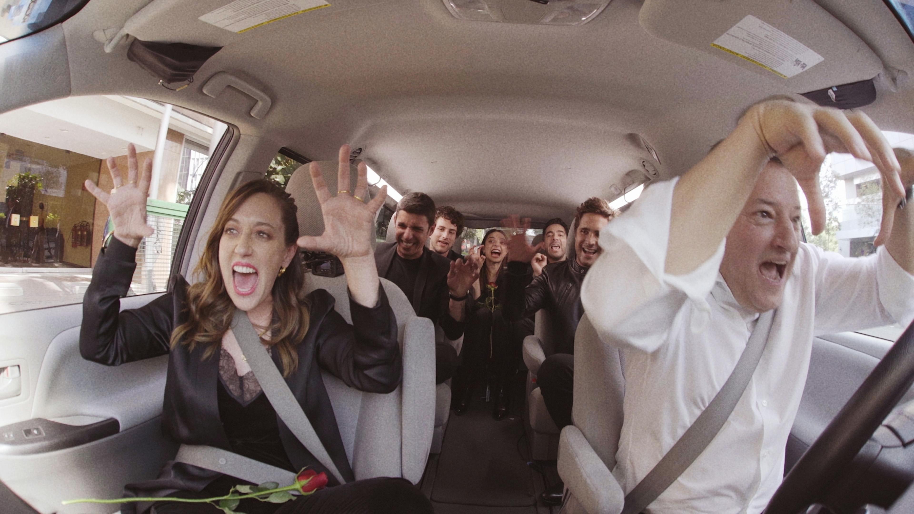 A couple singing and dancing in a limo