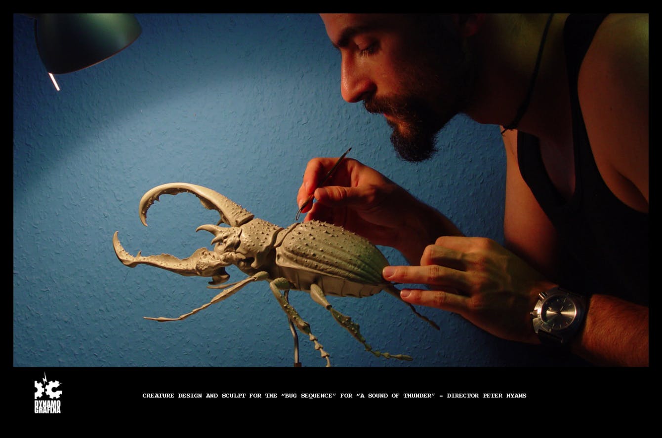 Photograph of a man making a model of a bug