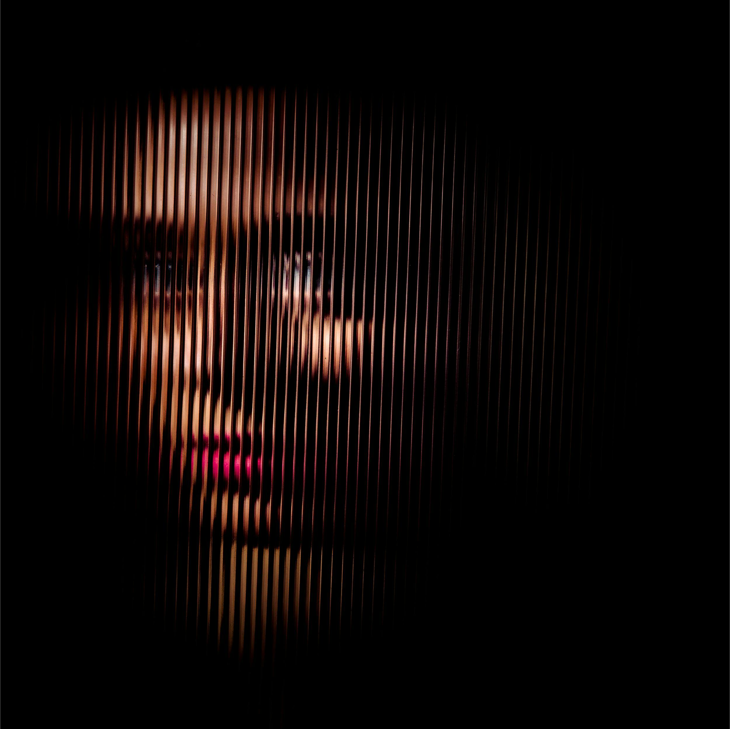 Woman looking through textured glass