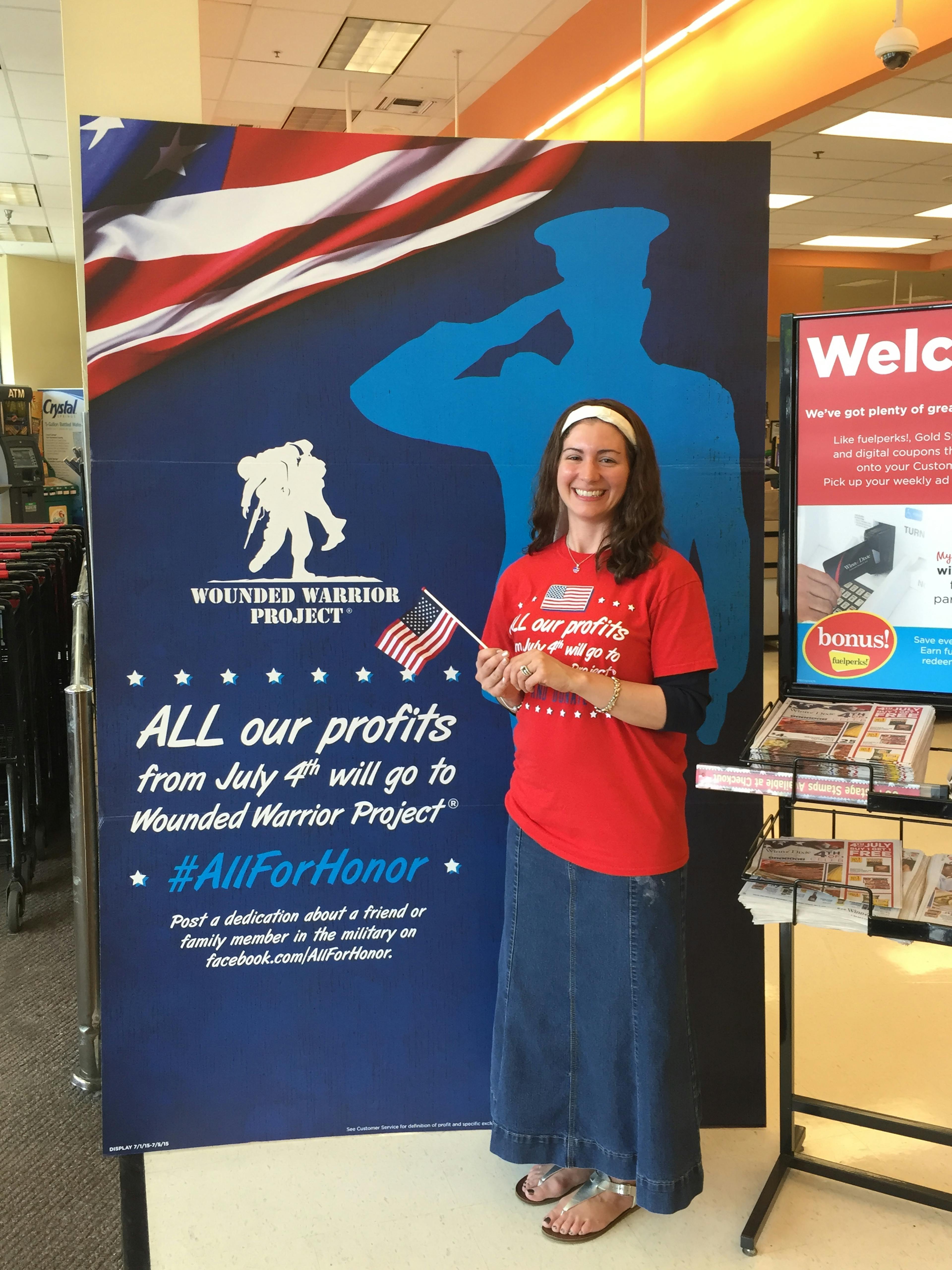Woman standing in front of Wounded Warrior poster