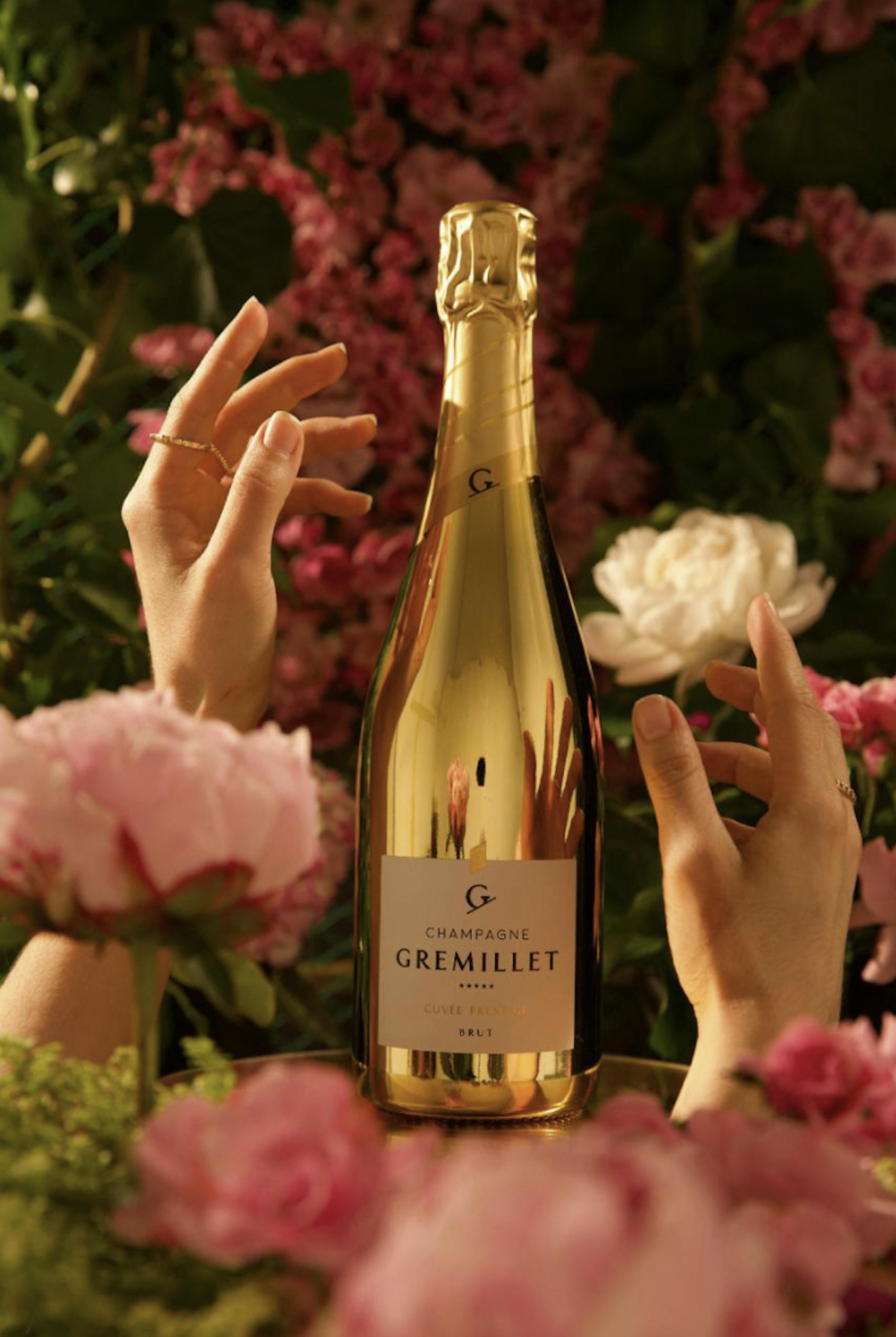 Hands reaching for golden bottle of wine