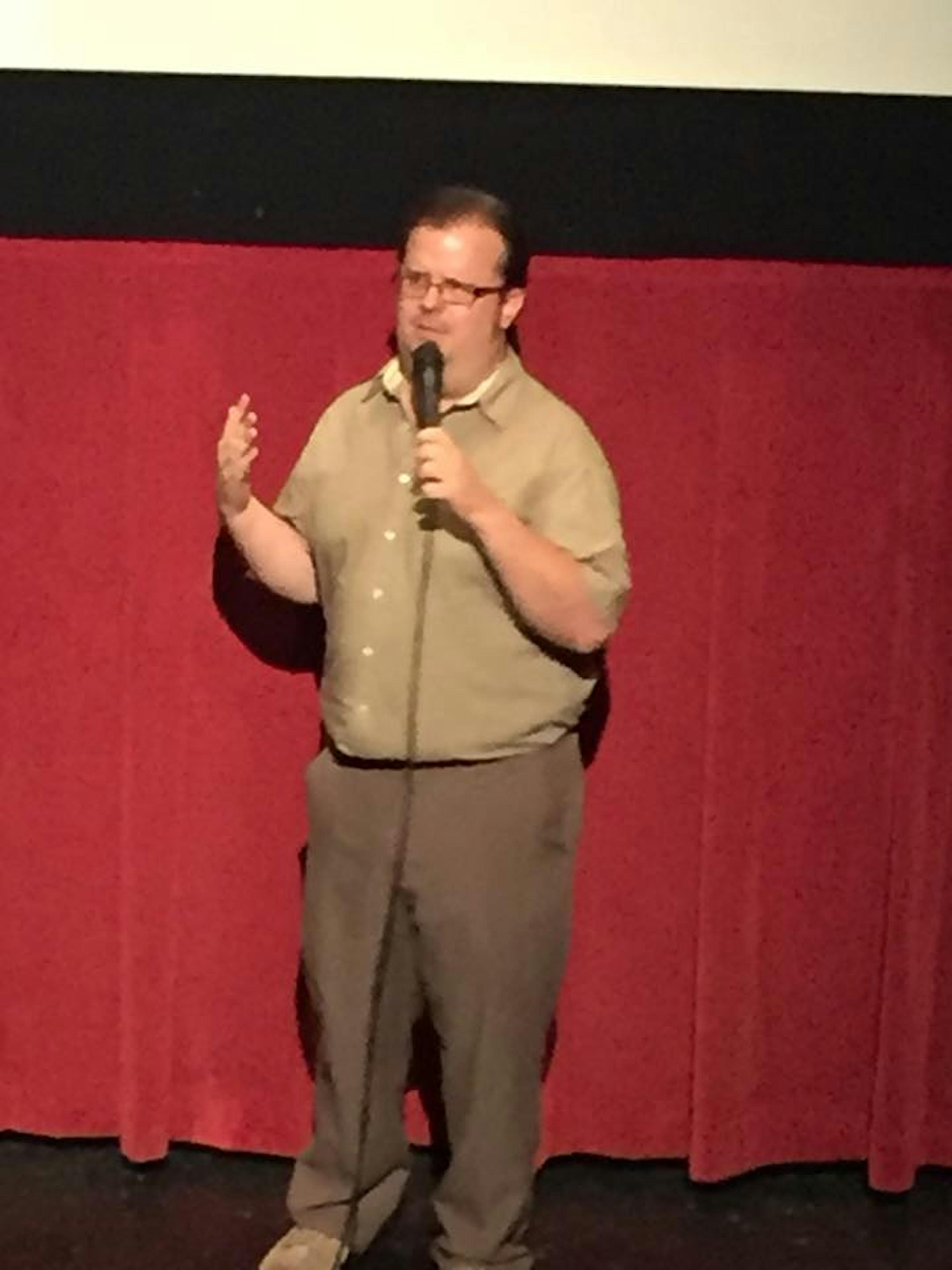 A man on stage holding a microphone