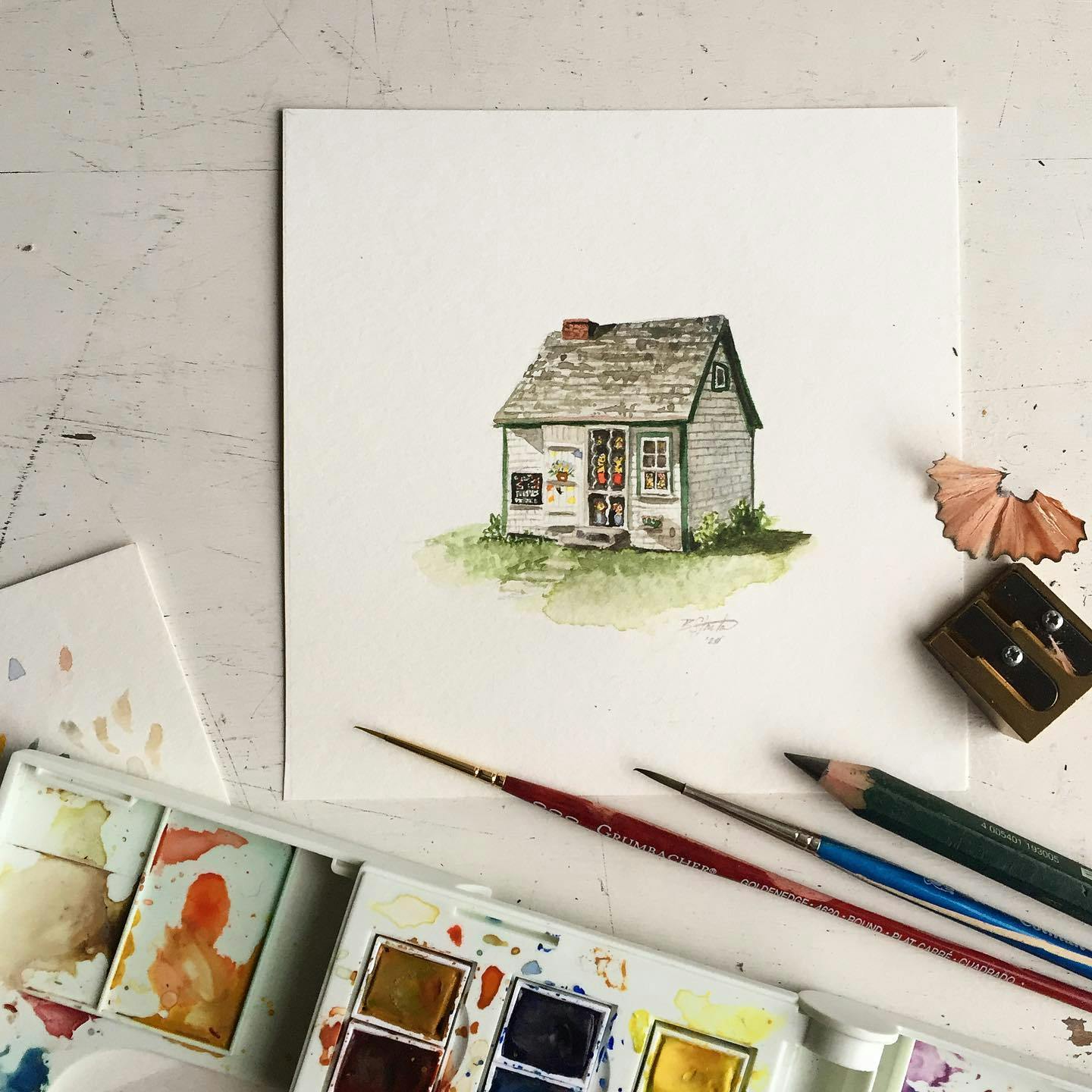 A watercolor painting of a cottage