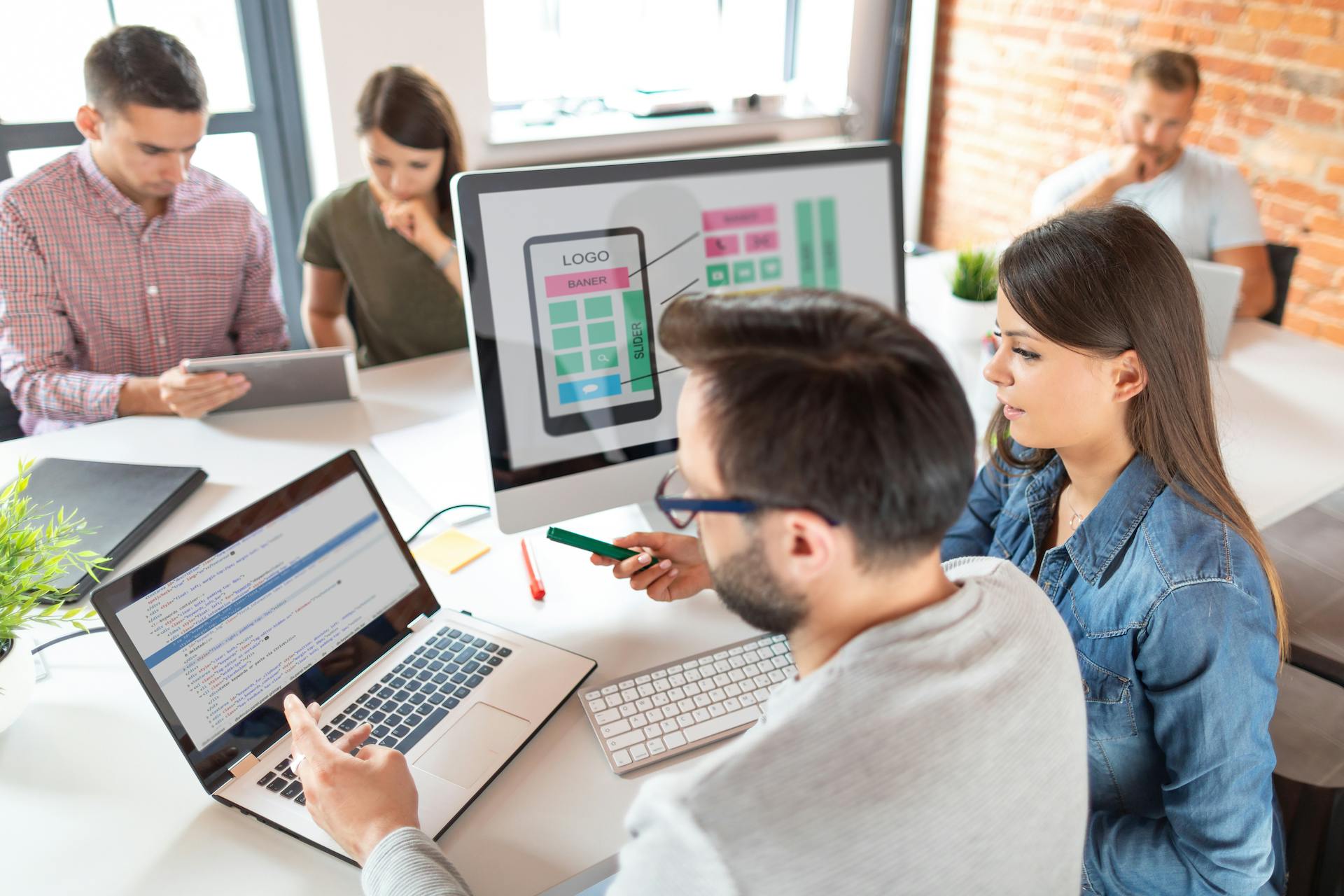 Stock photo of team looking at web mockups and code together