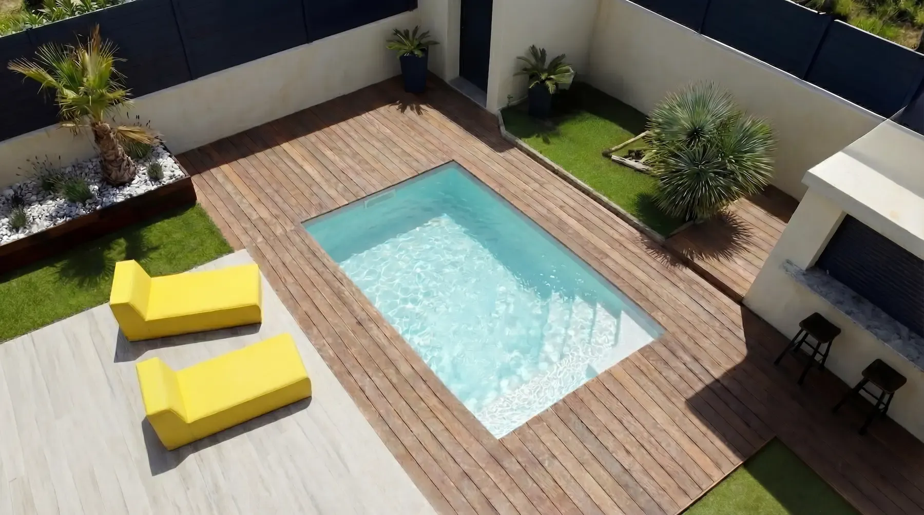 Modèle Star 4 installé à Marseille 9, deck en bois clair, transats jaunes et palmier dans massif minéral