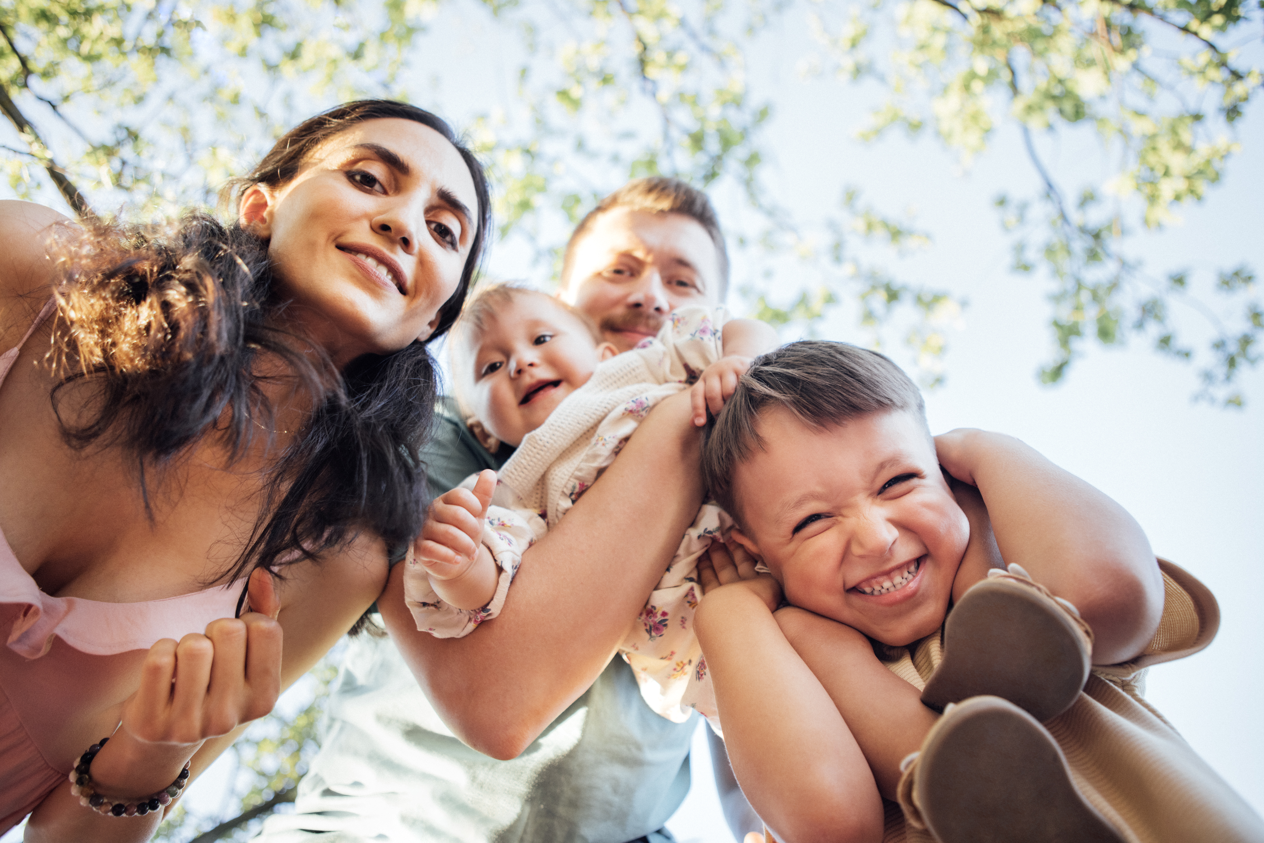 Caregiver and children together in a sunny garden, enjoying summer at home