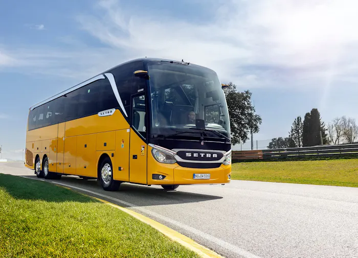 Setra hópferðabíll á ferðinni í góðu veðri, gul á litinn