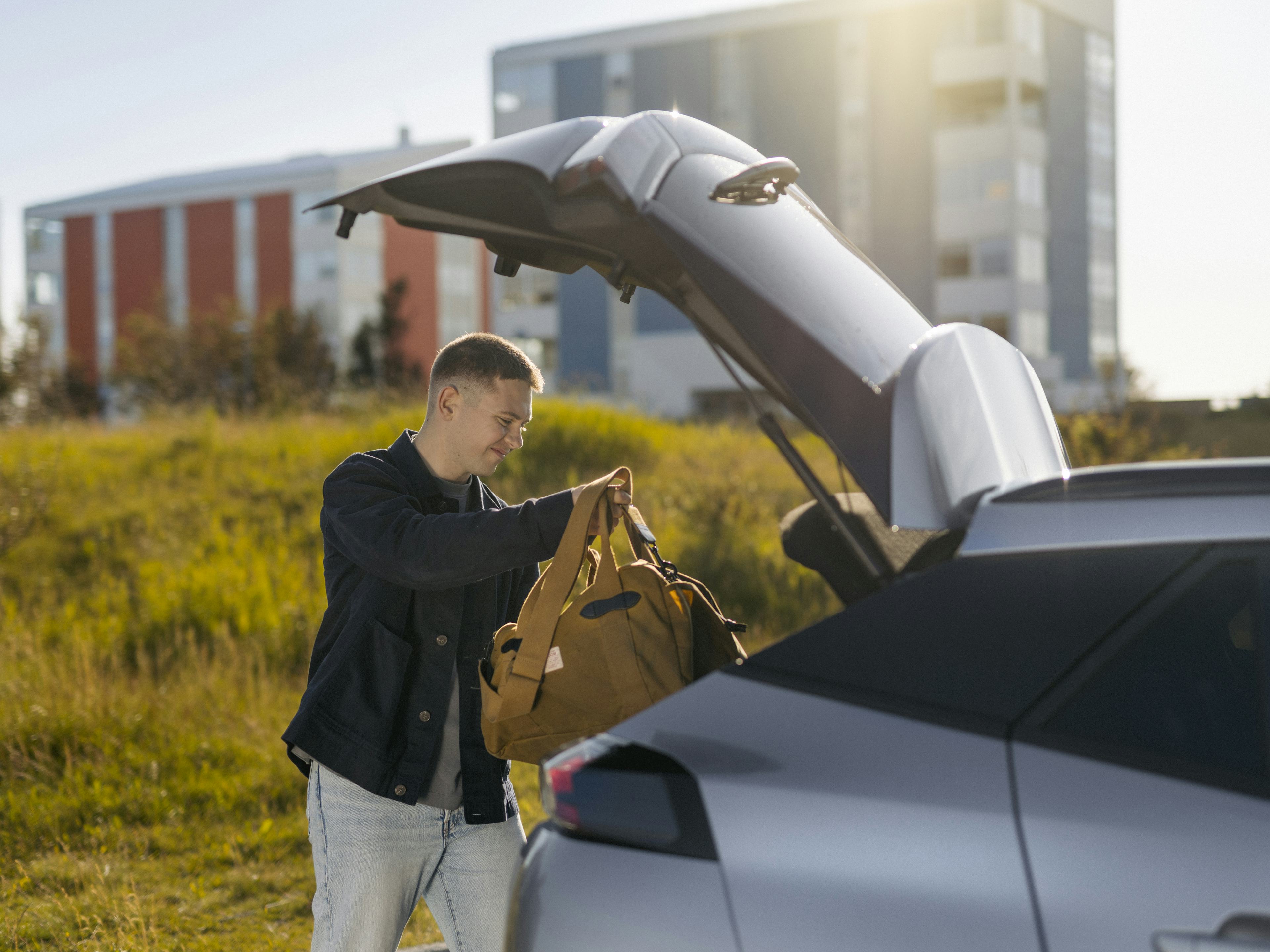 Maður hleður farangri í bíl
