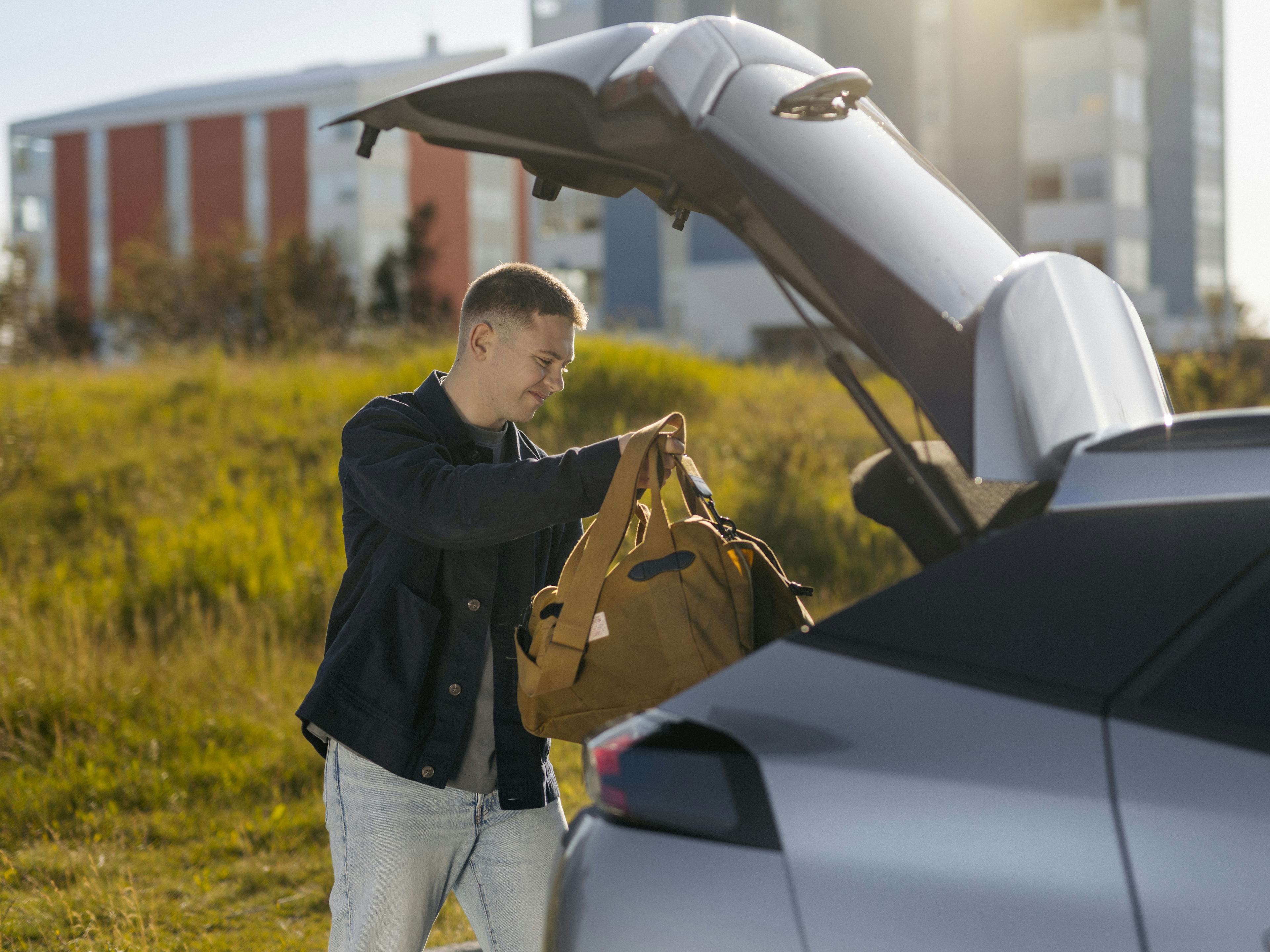 Maður hleður farangri í bíl